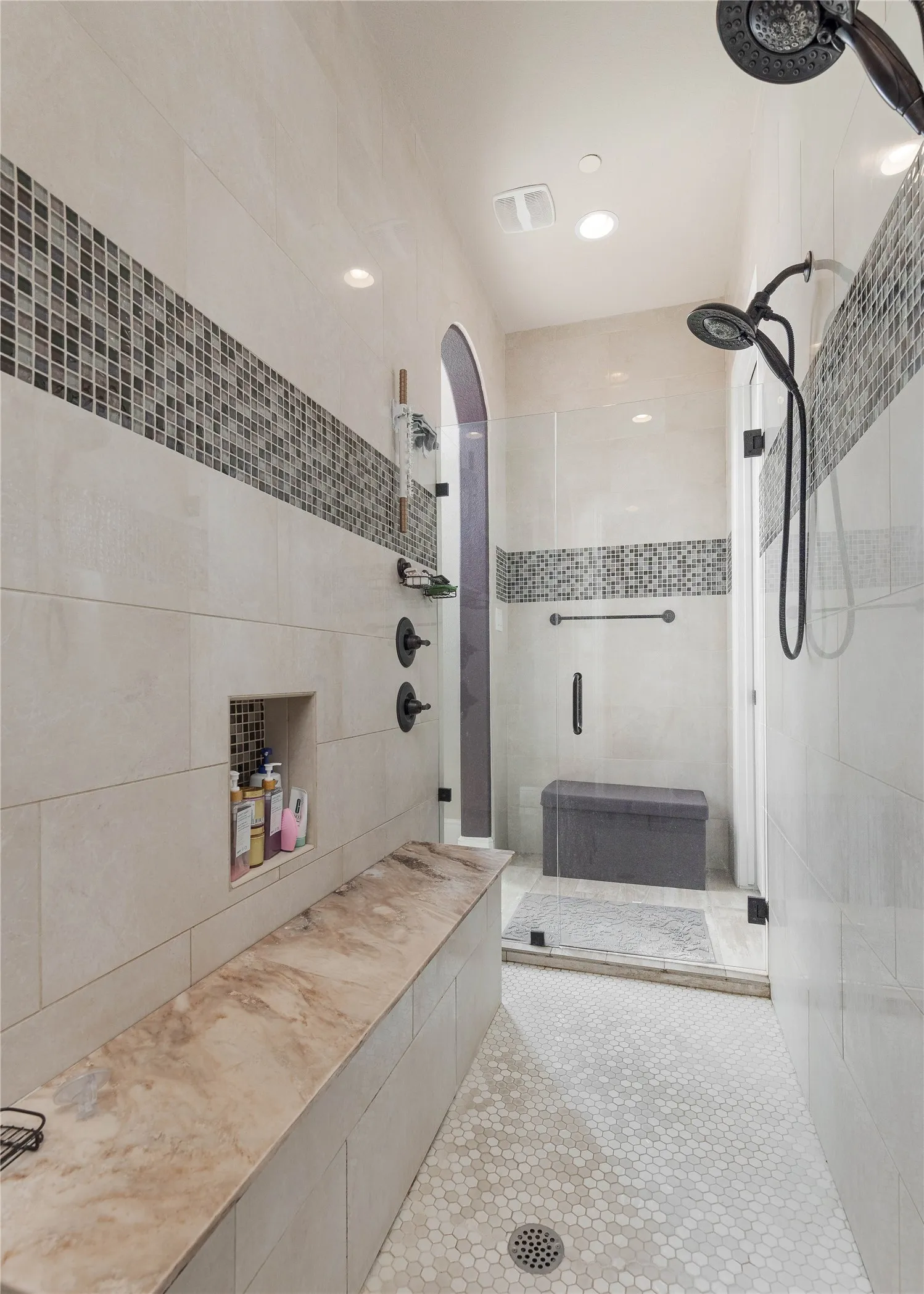 Full bath with tile walls, tile patterned floors, visible vents, and a stall shower