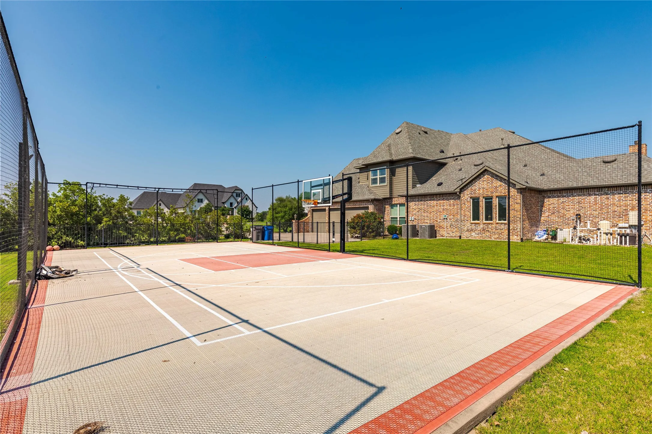 View of sport court featuring community basketball court, fence, and a lawn