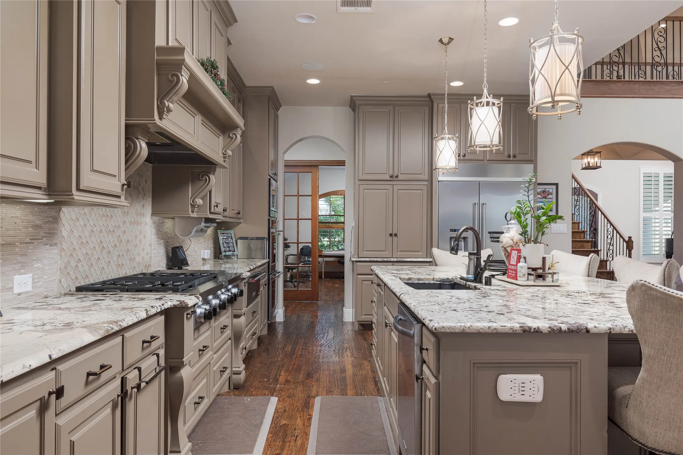 Kitchen featuring gray cabinetry, a sink, and arched walkways