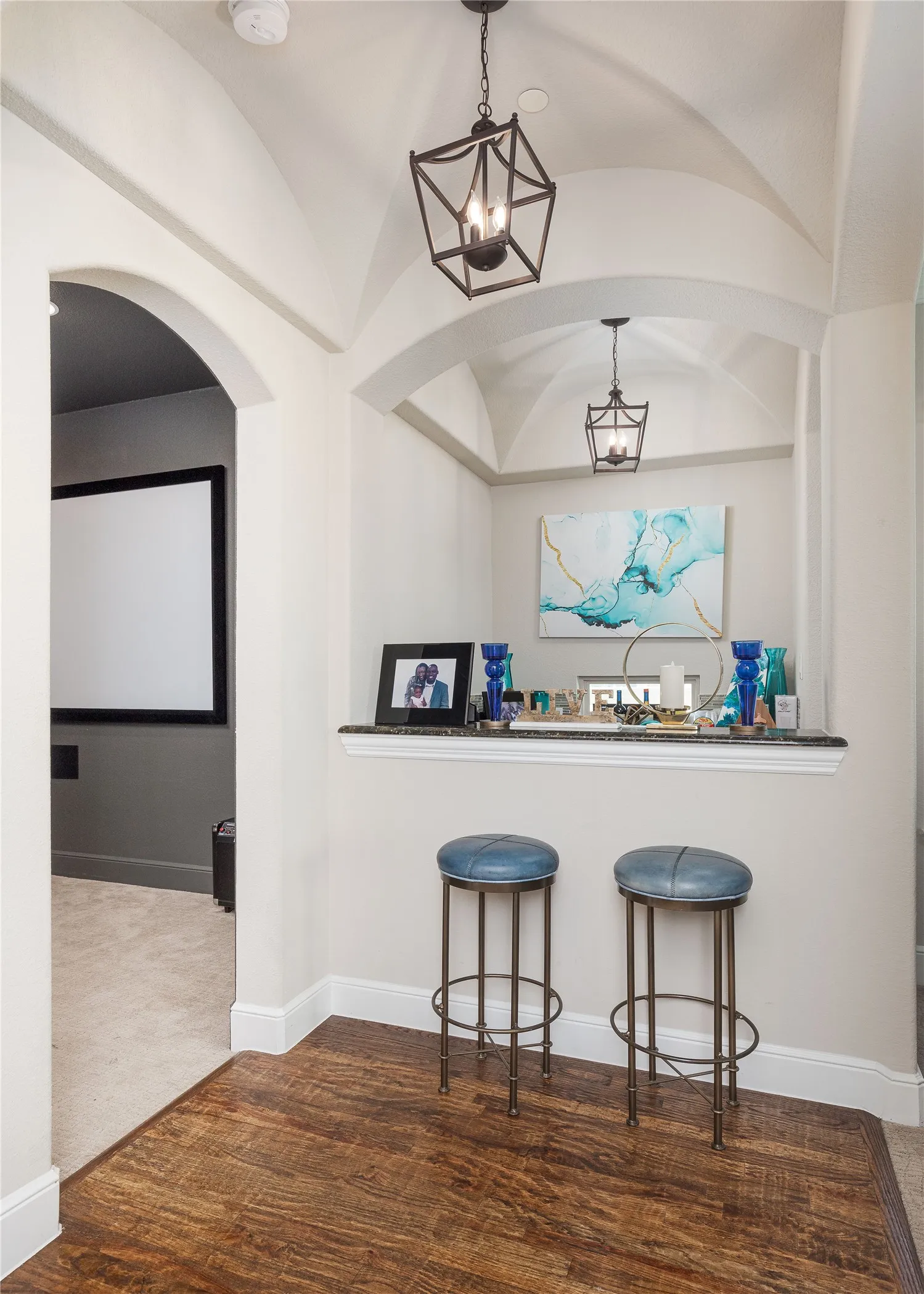 Bar featuring arched walkways, a notable chandelier, hanging light fixtures, and baseboards