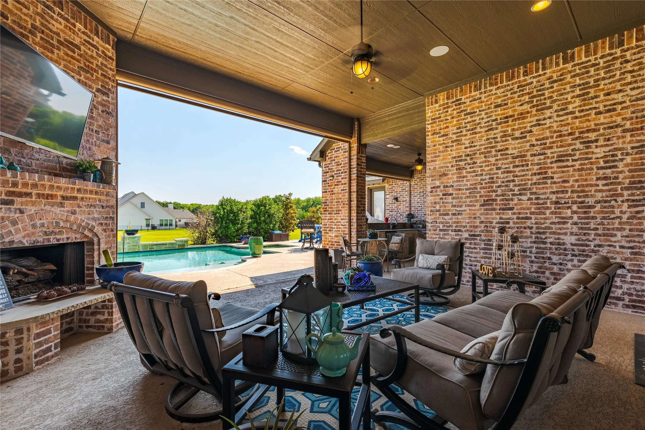View of patio with an outdoor living space with a fireplace, an outdoor pool, and ceiling fan