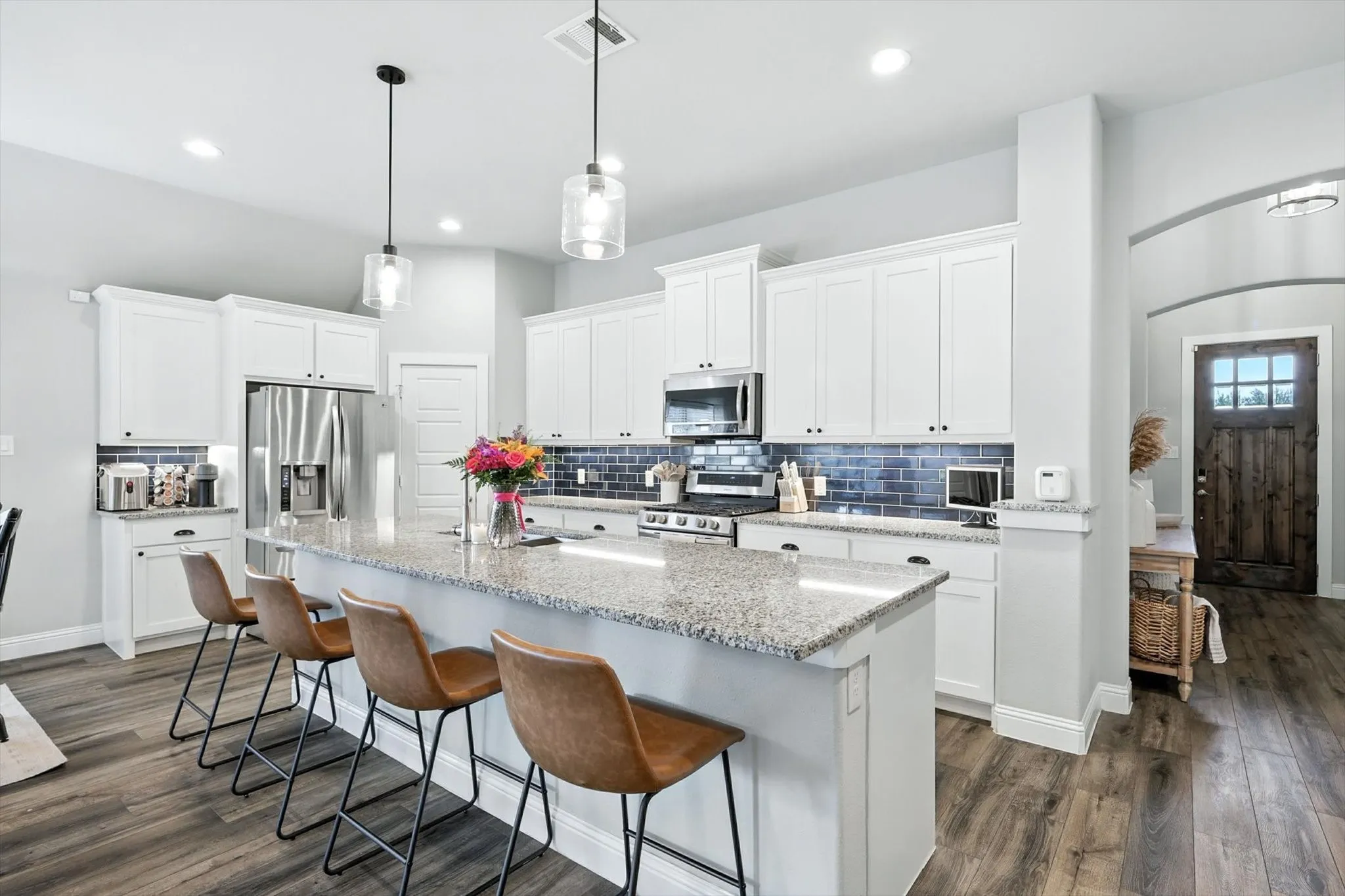 White kitchen with stainless appliances.