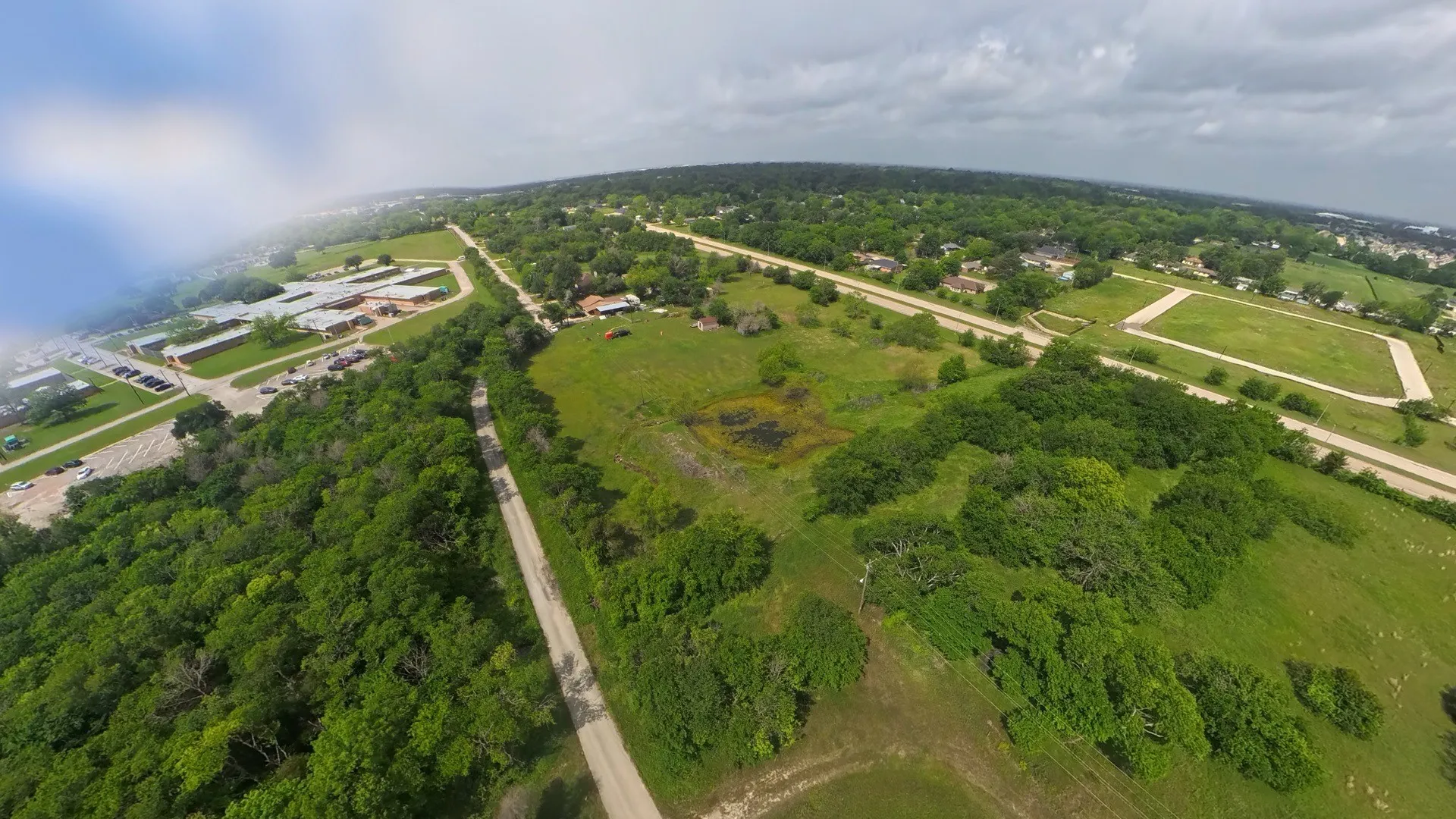 Expansive aerial view showcasing a landscape of mature trees and open green spaces