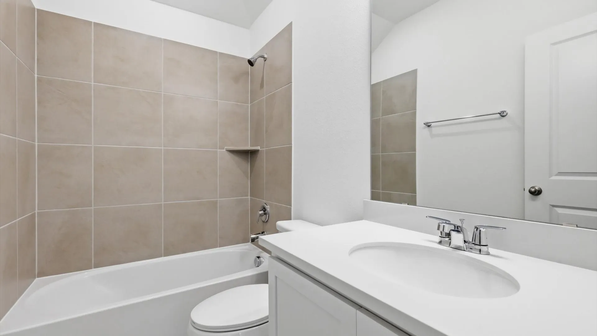Bathroom featuring a shower-tub combination with large-format wall tiling, a built-in shower niche, and a chrome showerhead