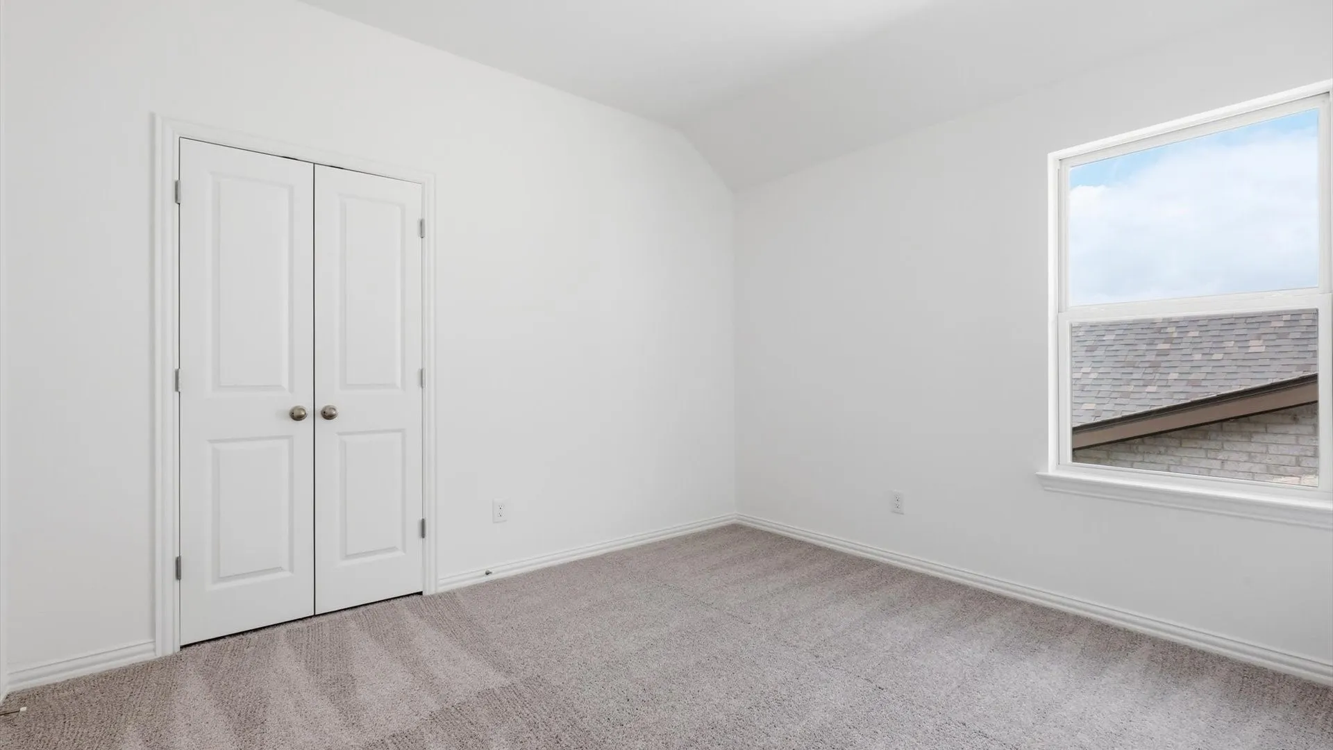 Room with gray carpeting, white walls, white trim, and a white-framed window