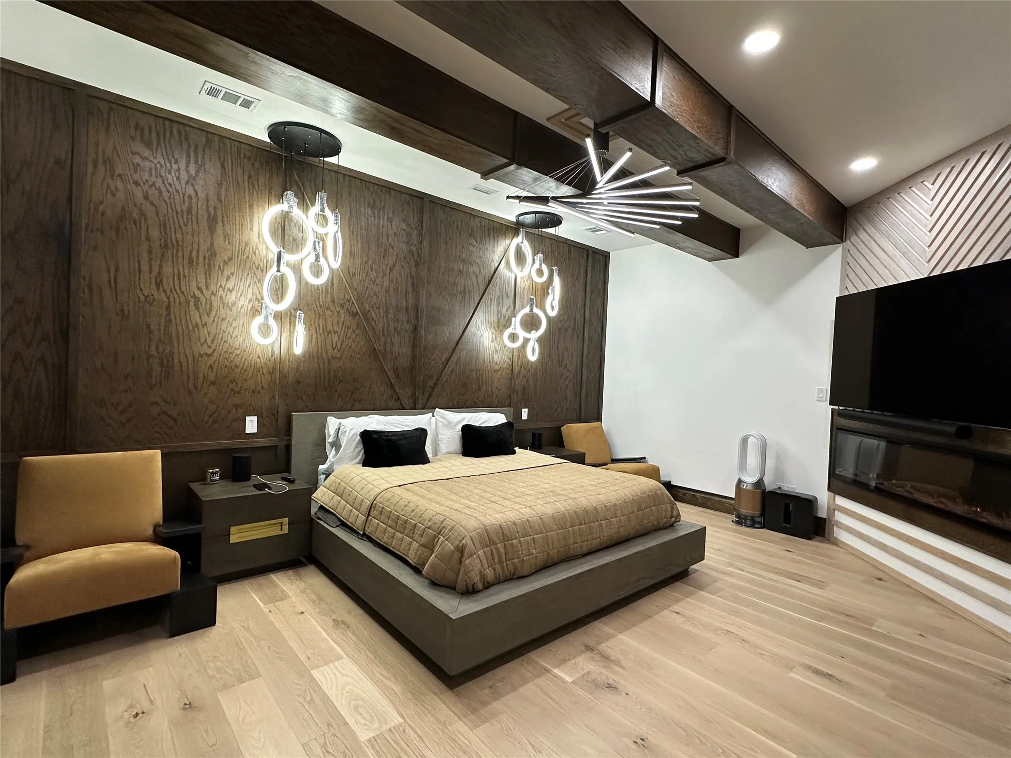 Bedroom with beamed ceiling and light wood-style floors