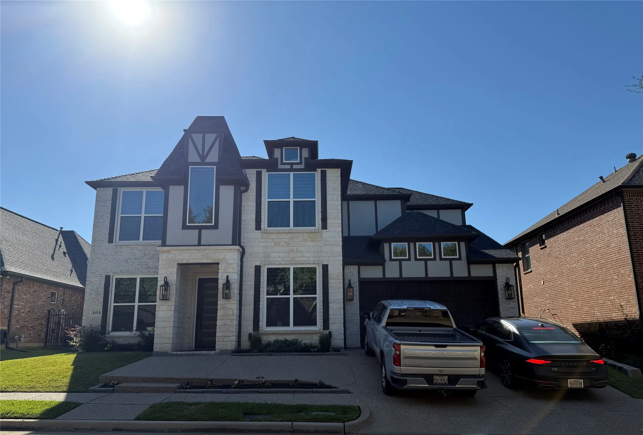 View of front of property featuring a garage, stone siding, and driveway