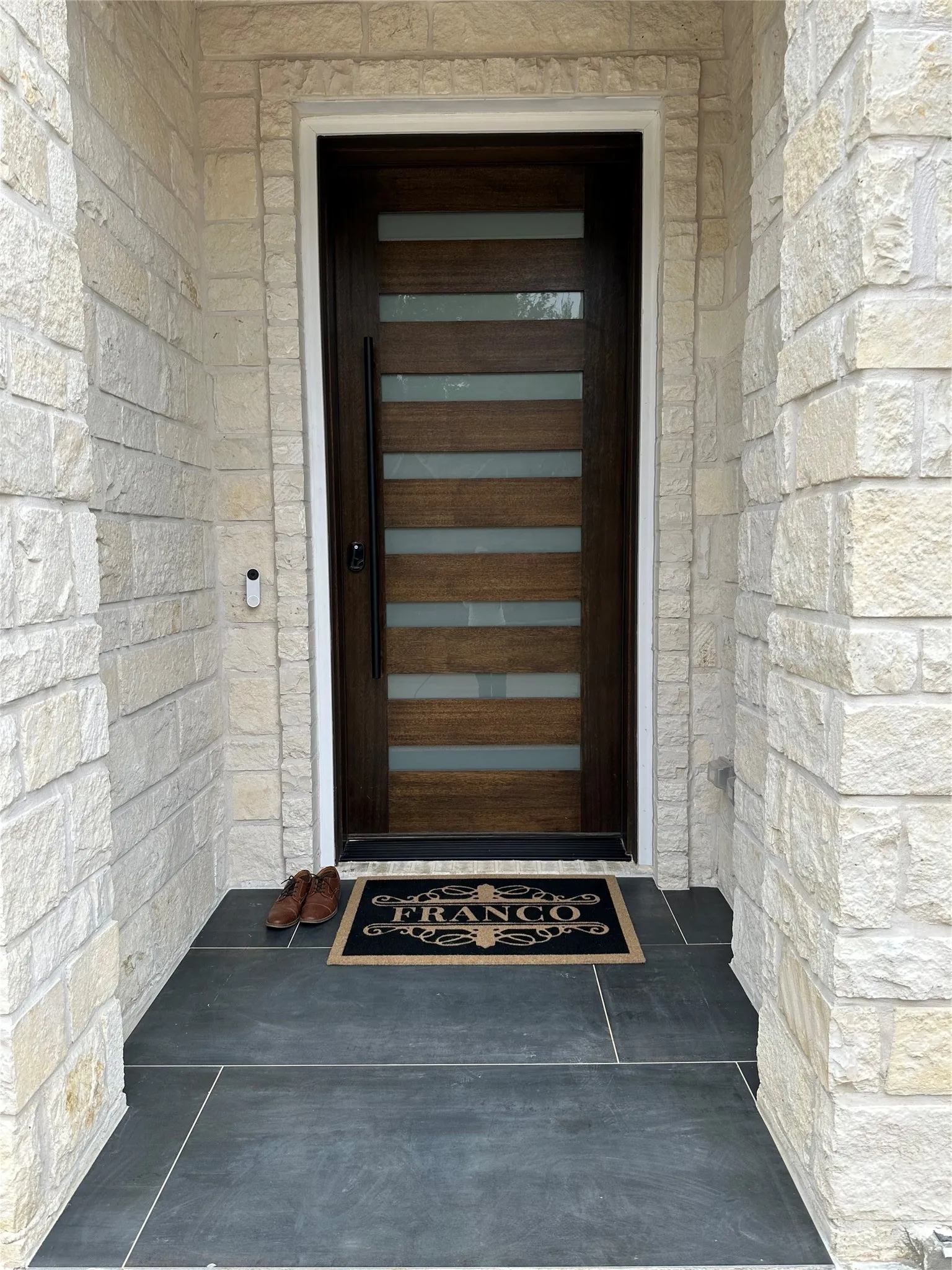 Doorway to property featuring stone siding