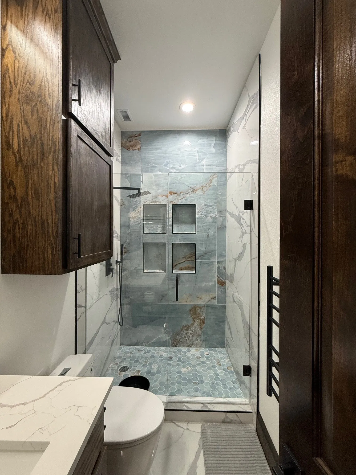 Bathroom with a marble finish shower, marble finish flooring, vanity, and recessed lighting