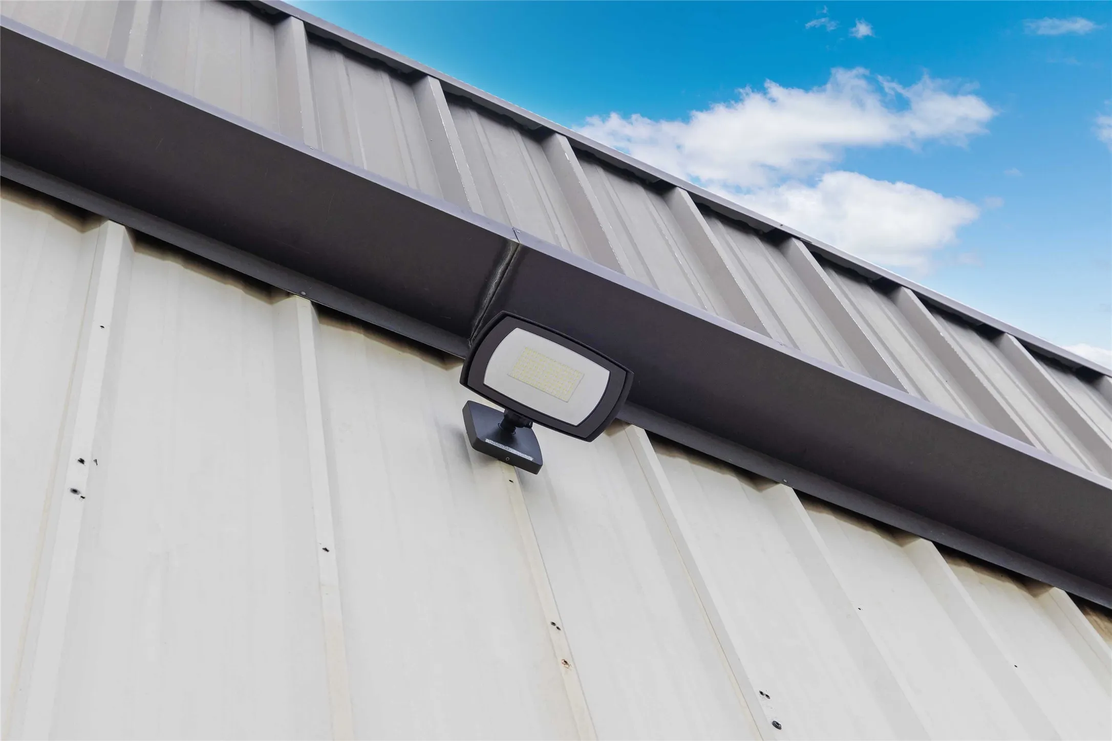 The property features corrugated metal siding and roofing, with an exterior light fixture mounted on the wall