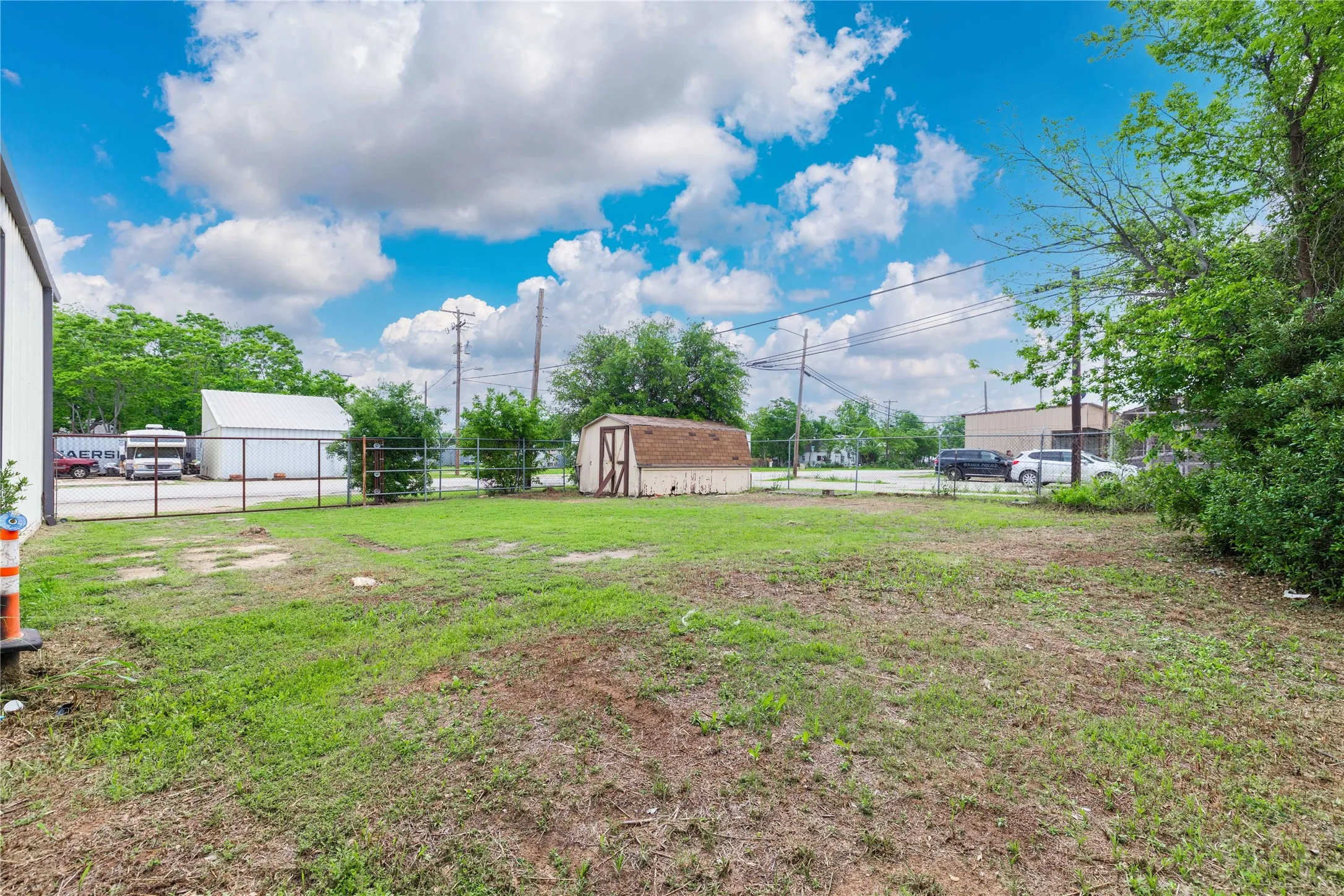 The property features an extensive outdoor area with a green lawn and a utility shed