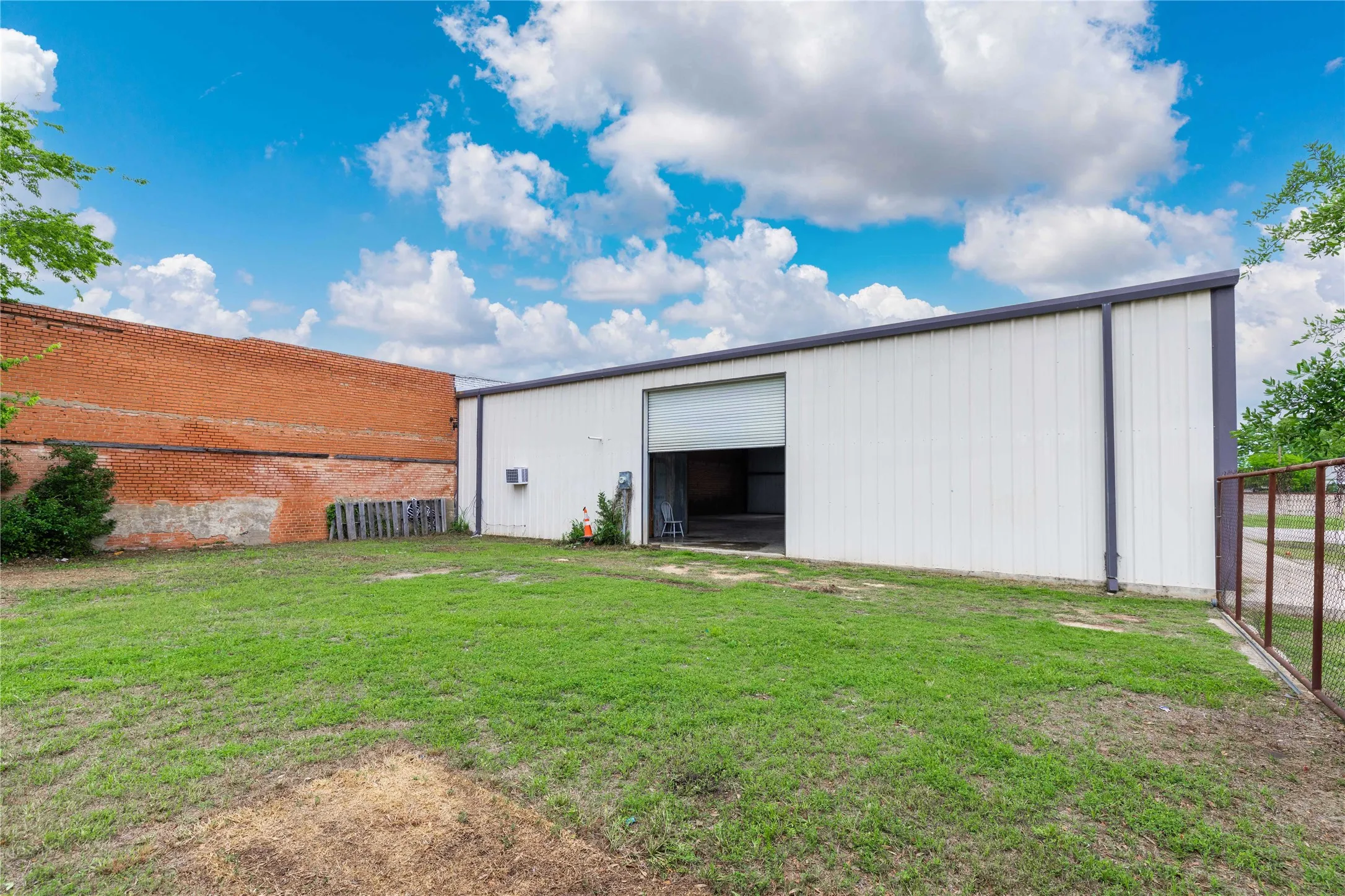 The property features a spacious grassy area and a large building with a roll-up door