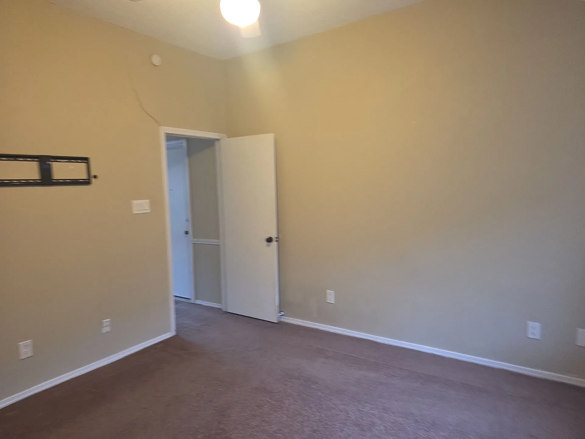 Room featuring neutral-toned walls, brown carpet, and a white ceiling with an overhead light fixture