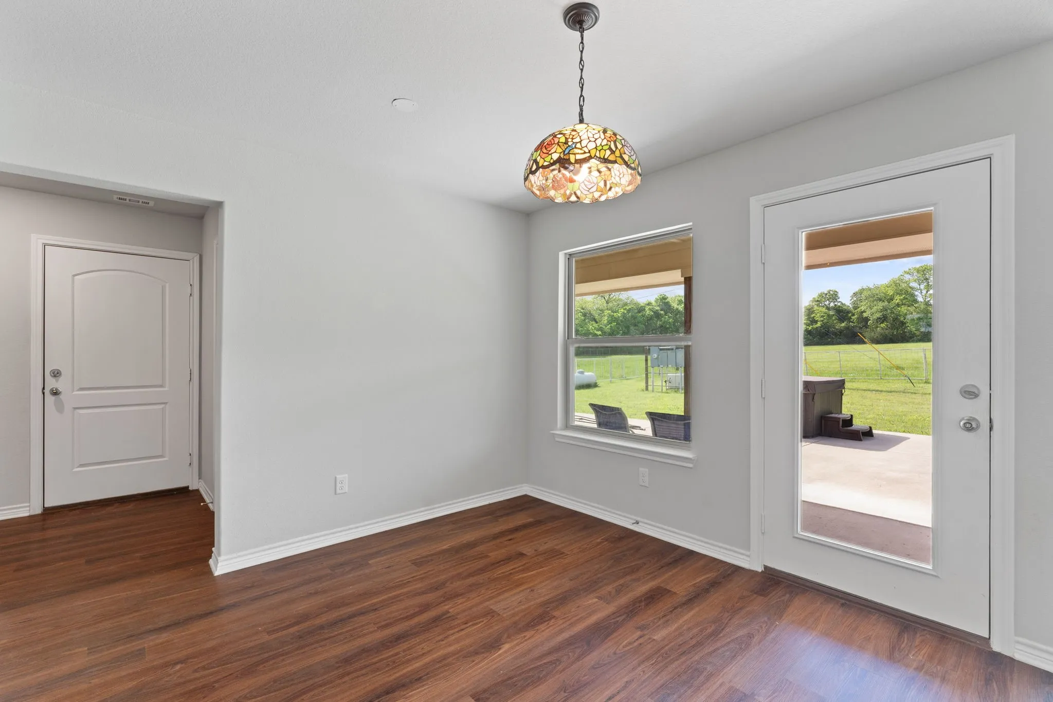 Dining room with view of patio, jacuzzi, and pasture