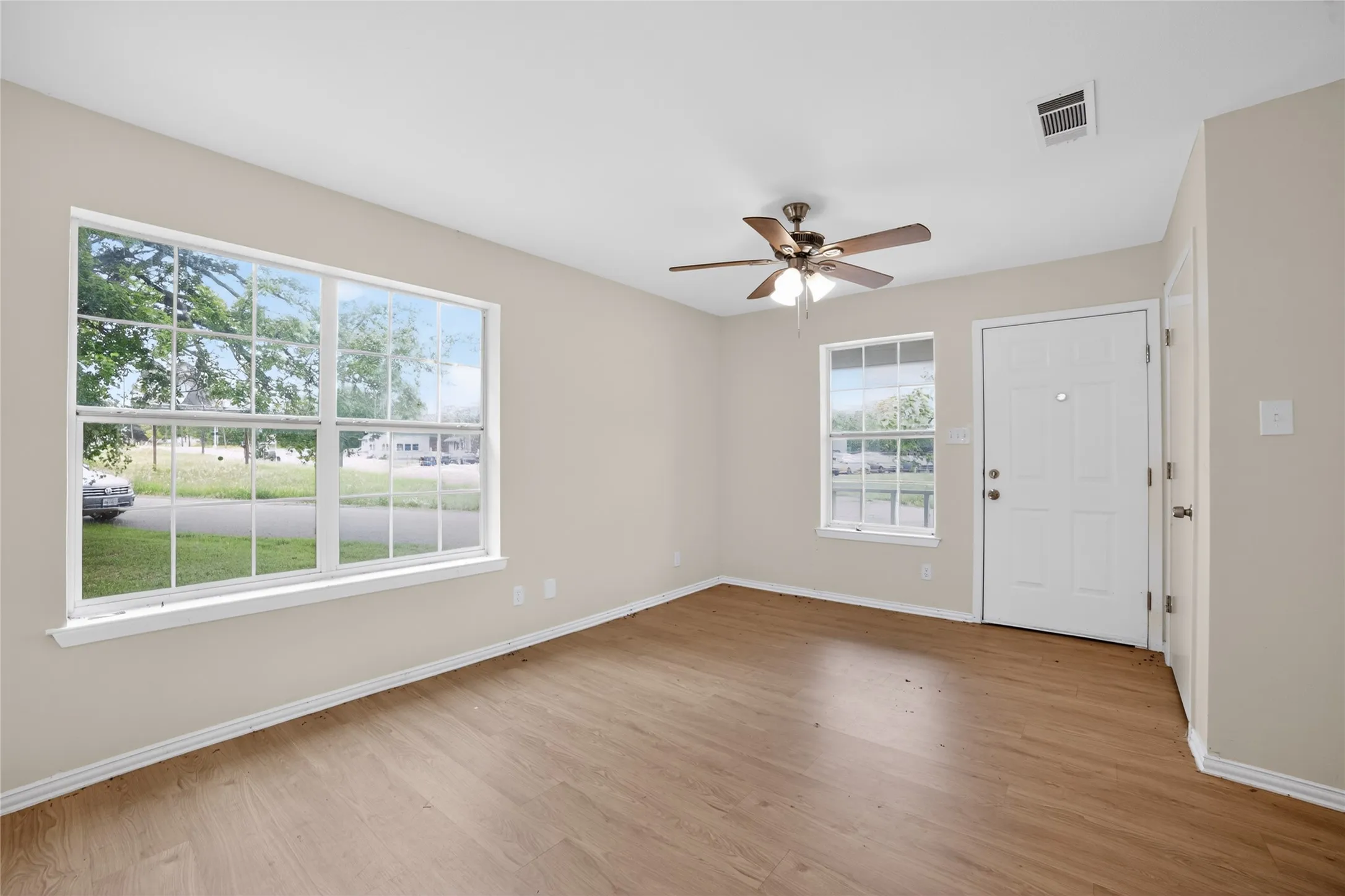 The property features warm-toned flooring, light-colored walls, and a ceiling fan with integrated lighting