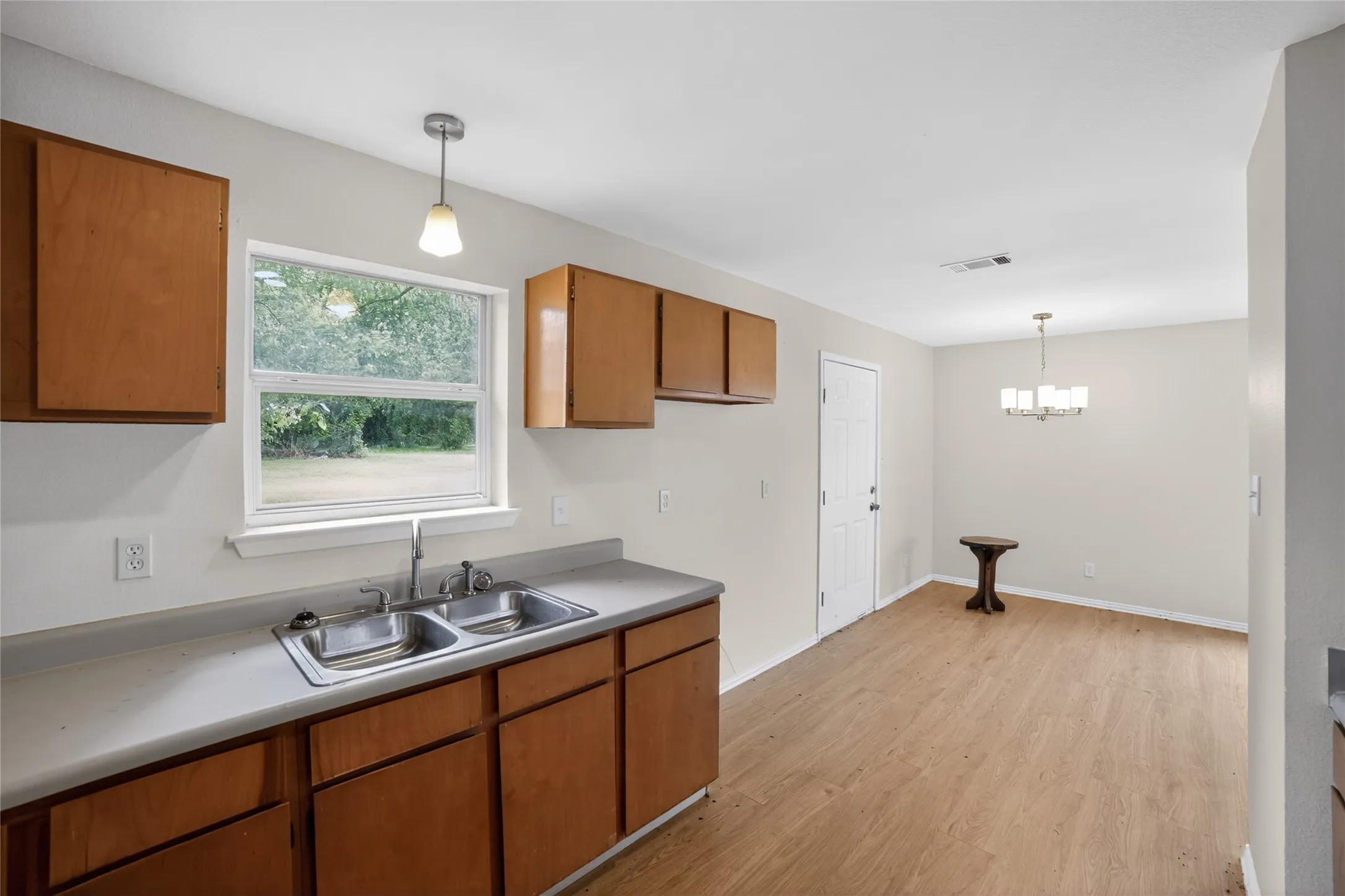 The property includes a kitchen with wood cabinetry, a double basin stainless steel sink, and light-colored countertops