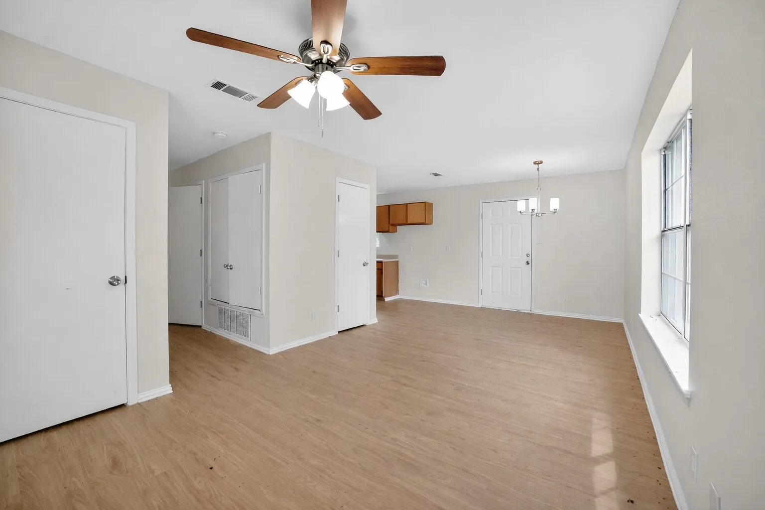 Open concept living area featuring light wood-look flooring and light-colored walls