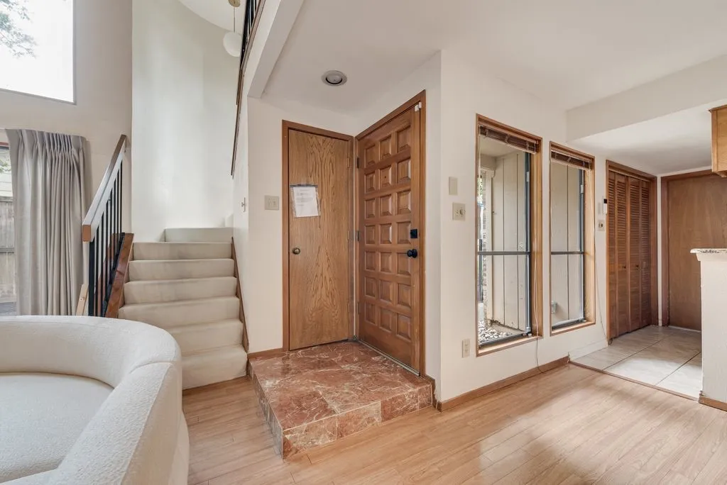 A warm entry with natural textures and a marbled tile landing sets the tone for the architectural character inside.