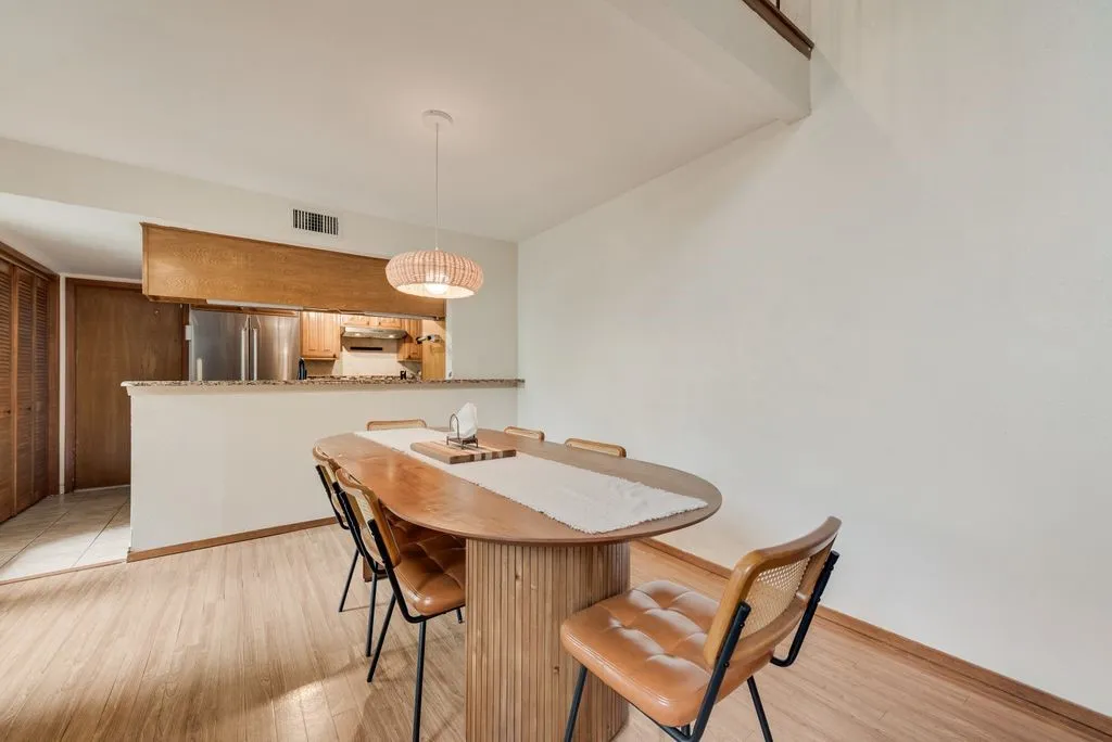 The dining area offers an intimate setting with designer lighting and an easy connection to the kitchen.