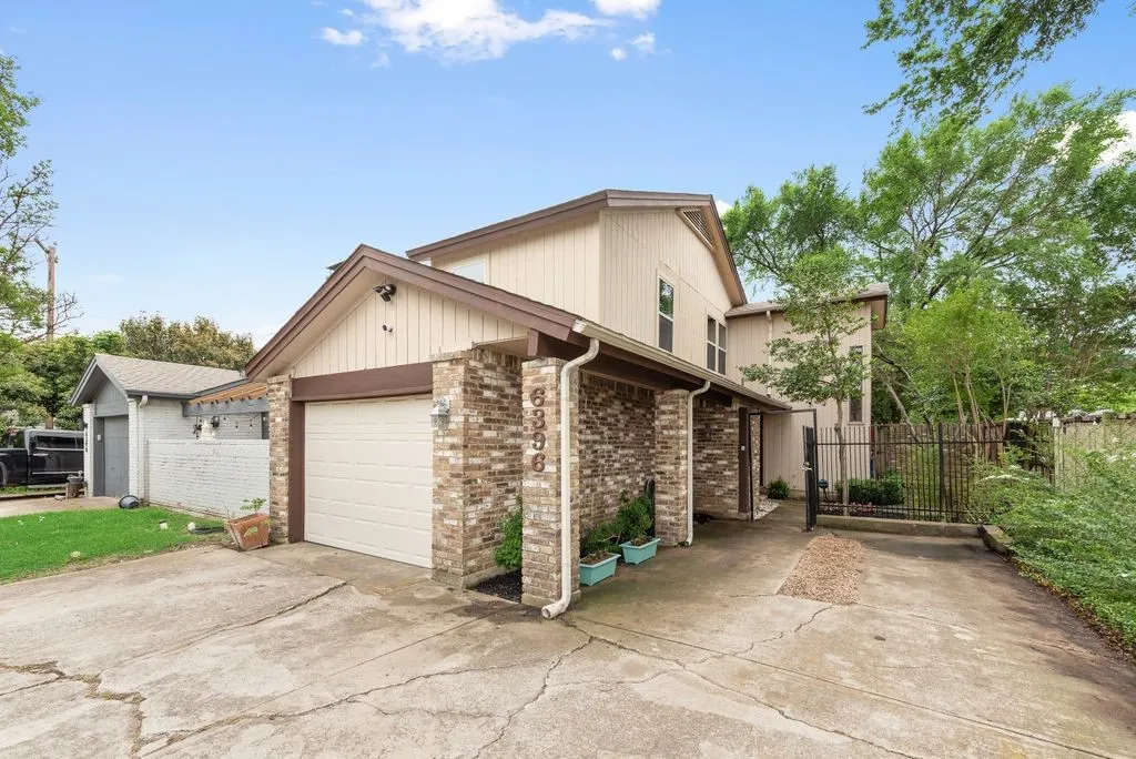 The exterior combines brick and siding with a gated entry, reinforcing the home’s sense of privacy.