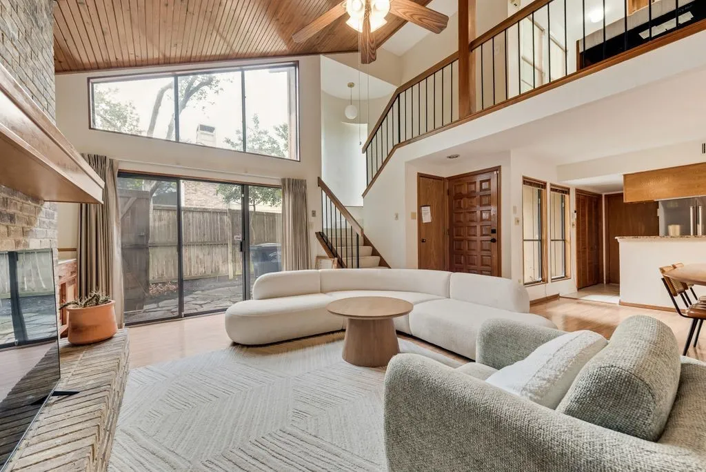 Expansive windows and sliding glass doors fill the space with light while creating a seamless indoor-outdoor connection.