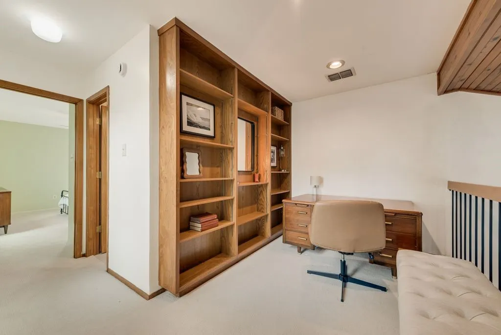Built-in shelving and a dedicated workspace offer a functional area for work or study in the loft.