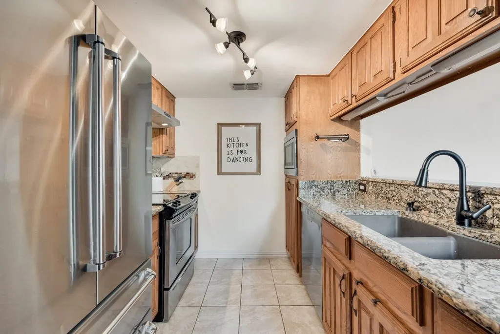 A streamlined layout with stainless appliances and natural finishes supports effortless everyday living.