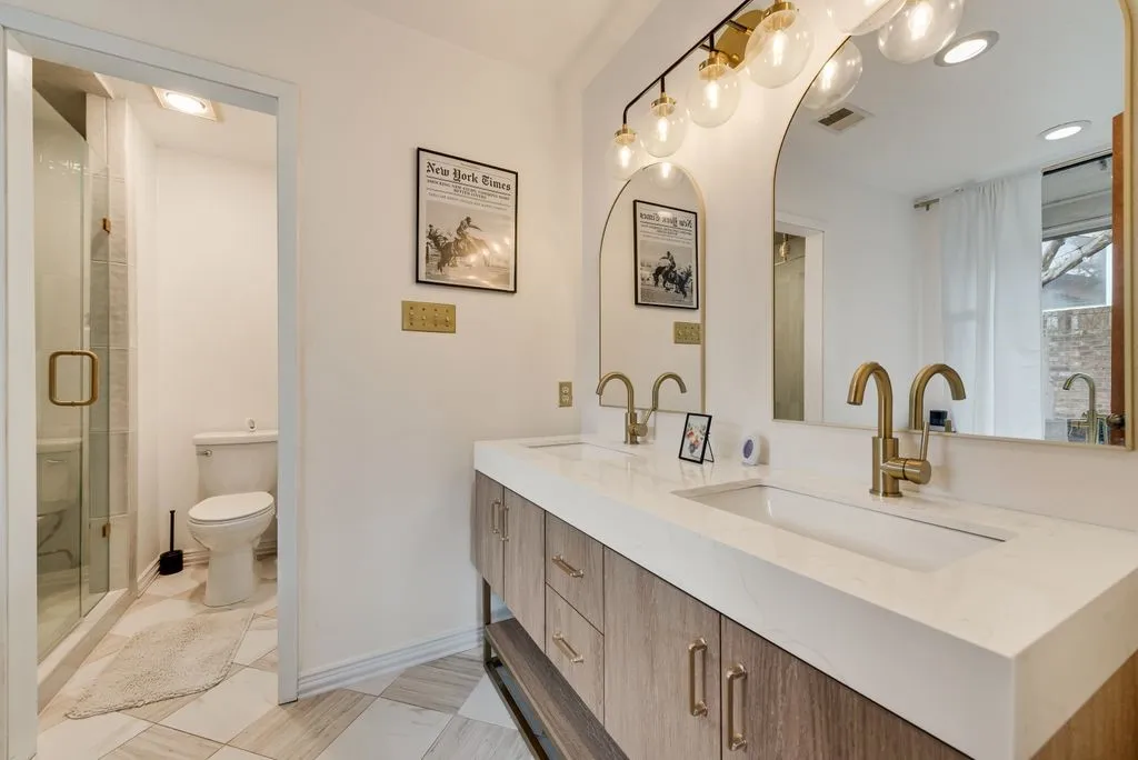 One side of the primary bath features a dual-sink vanity and freestanding soaking tub, creating a bright and open space.