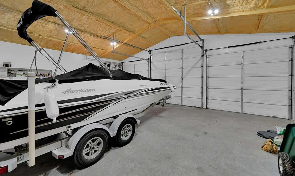 Fully insulated Spacious 2nd  garage featuring two large garage doors, a concrete floor, and an insulated ceiling with exposed beams. work shop & studio apartment within the structure