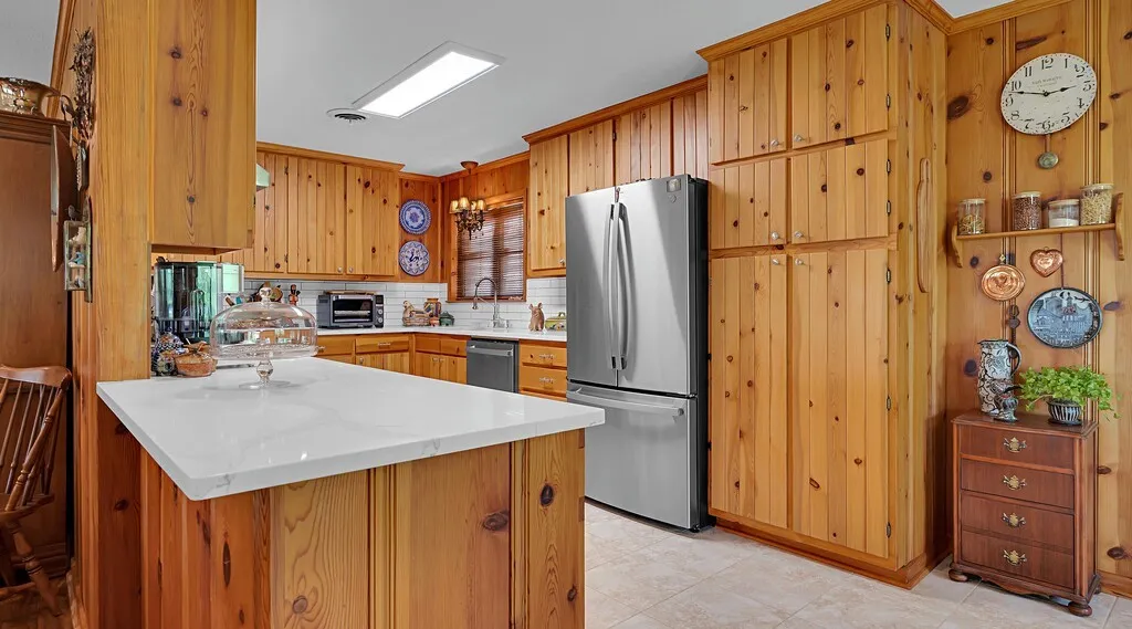 The kitchen opens to living area and dining area. features extensive high quality cabinetry and stainless steel appliances, quartz counter tops and decorator coordinated backsplash and recessed pantry