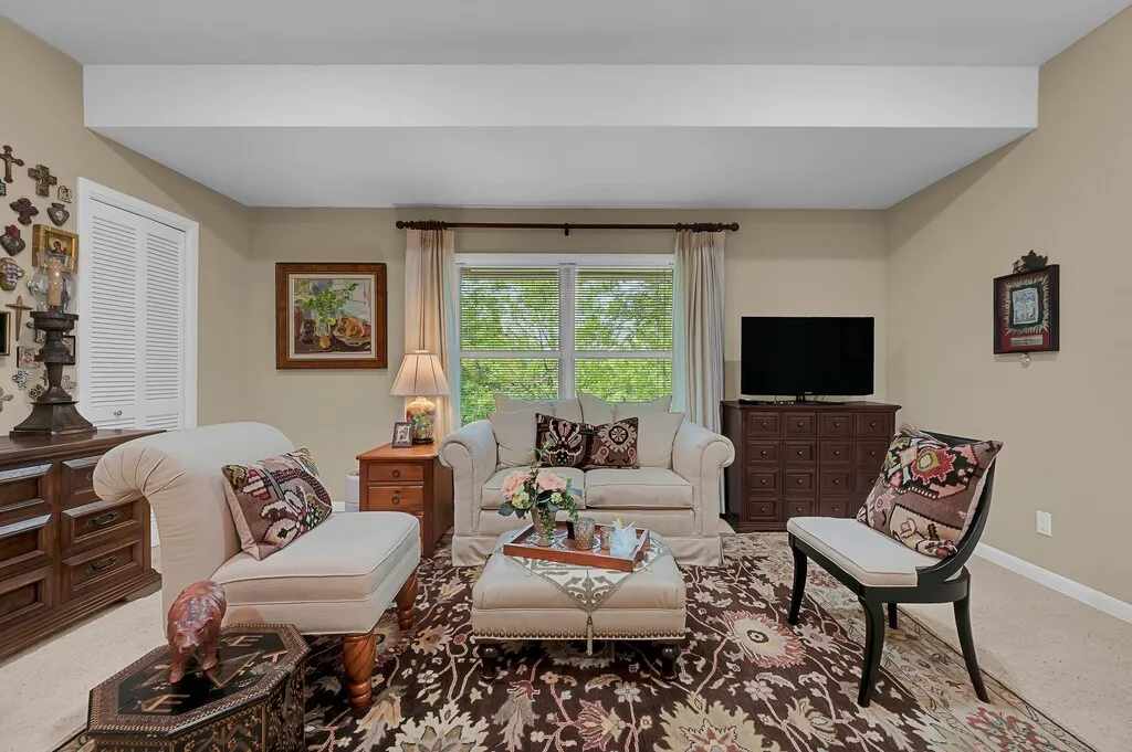 This living space in separate wing  features a large window with custom drapery, providing natural light