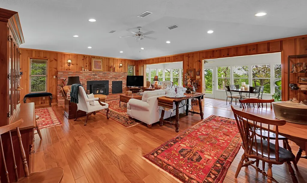 Expansive Buck Stove  fireplace and Sumroom woth 0ver 30 feet of windows create multiple gathering areas