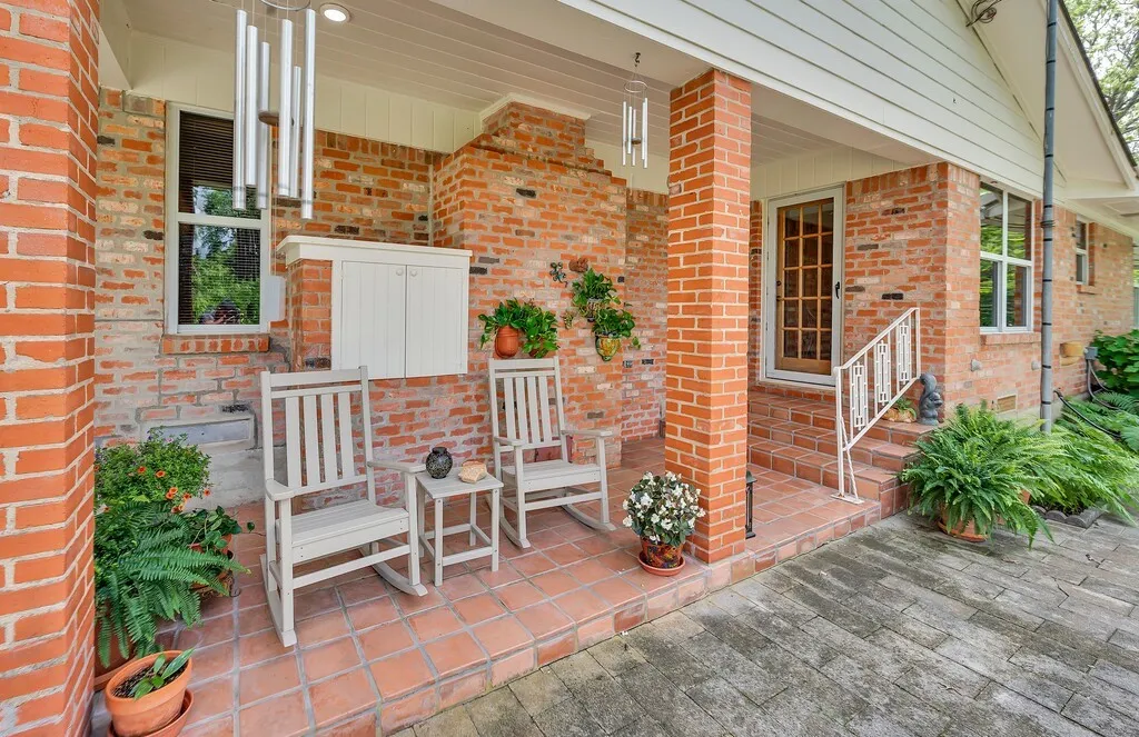 Just outside the kitchen an inviting, sturdy brick exterior with a covered porch