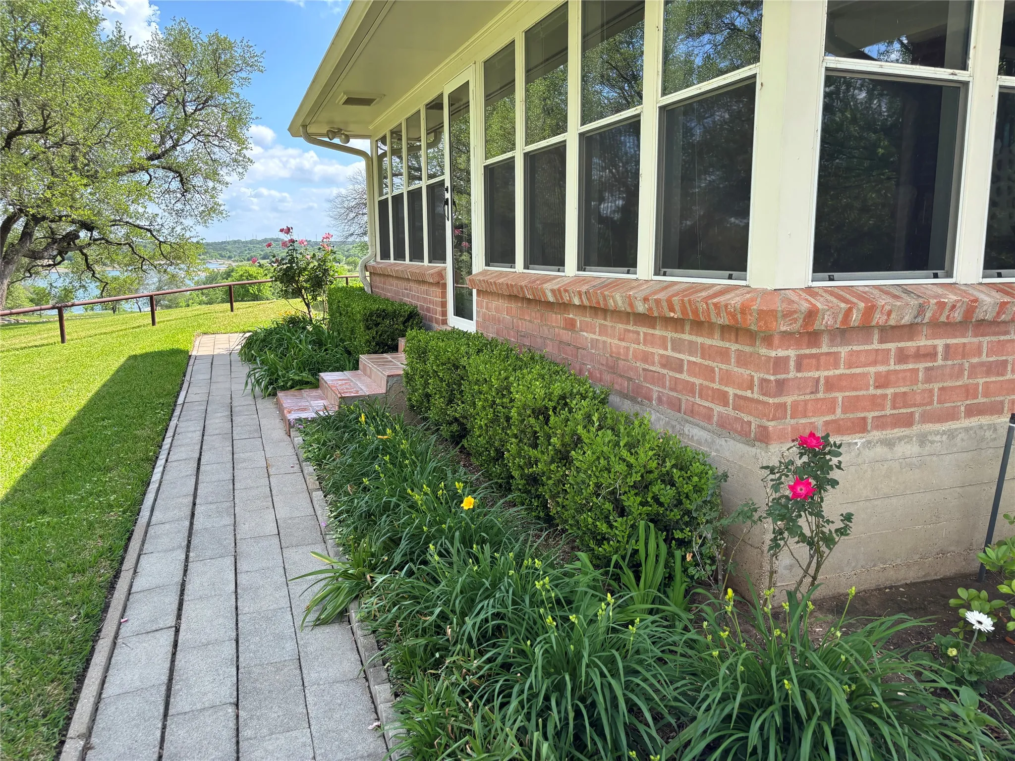 View of side of property with a lawn and brick siding