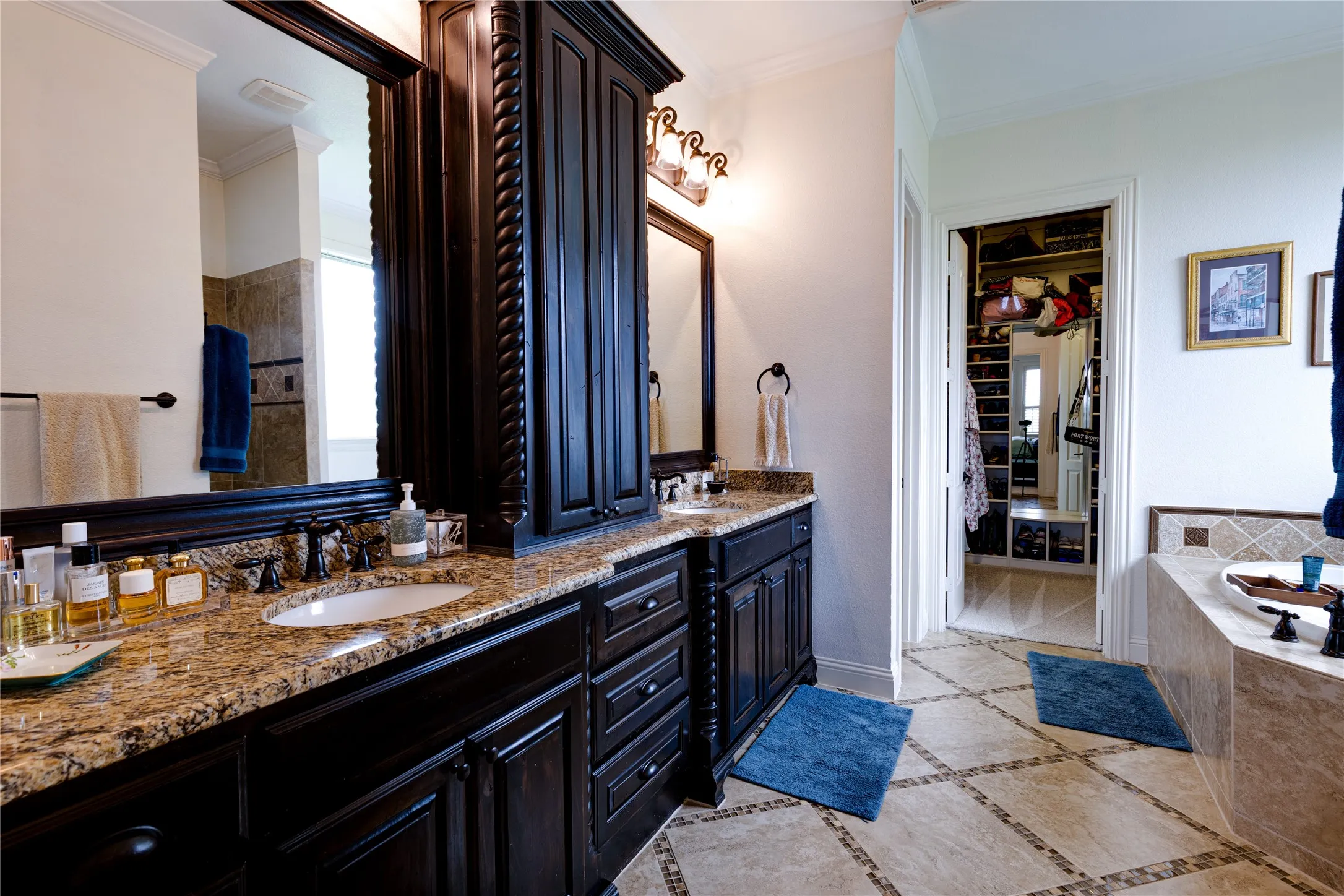 Primary bathroom with double vanities, storage and large walk in closet