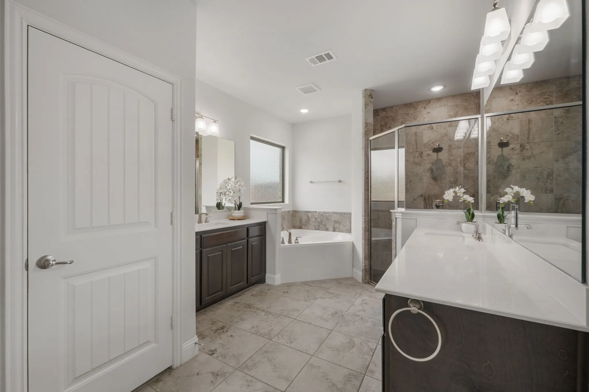 Primary bathroom with double vanities and large walk in shower with dual shower heads