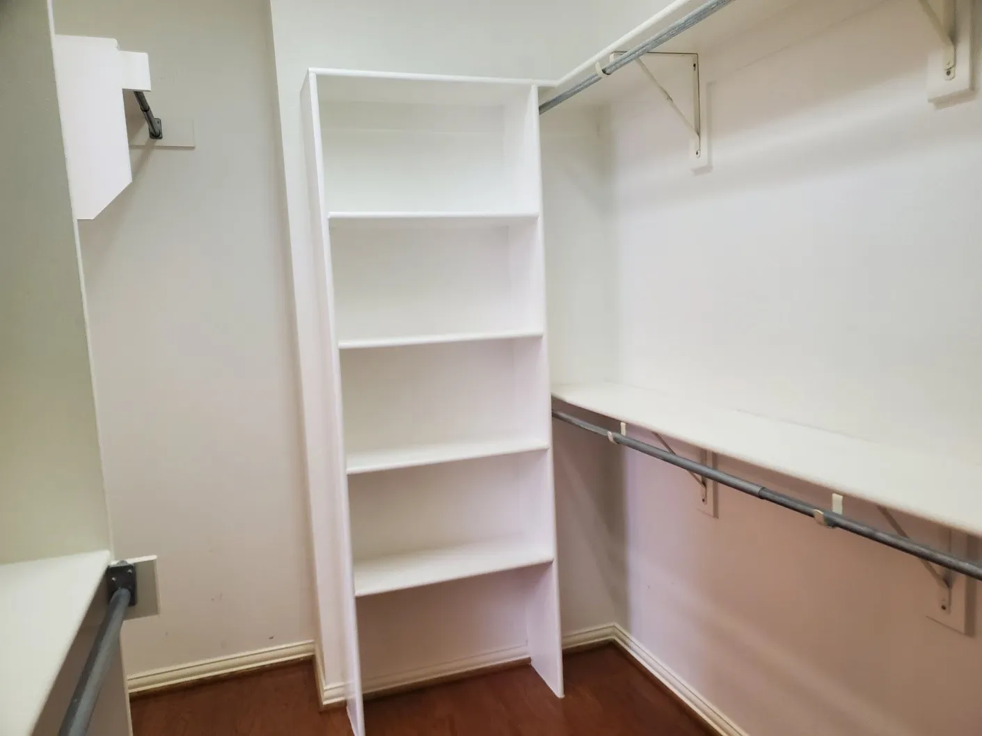 White closet system featuring built-in shelving and multiple hanging rods