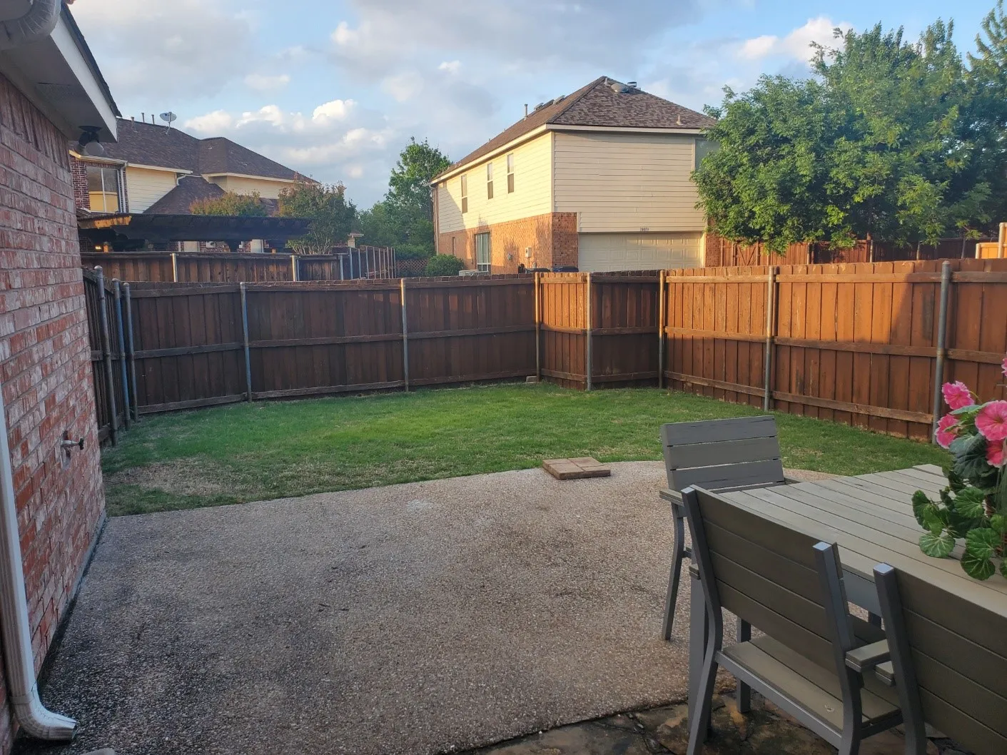 Private backyard featuring a concrete patio, fenced perimeter, and green lawn space