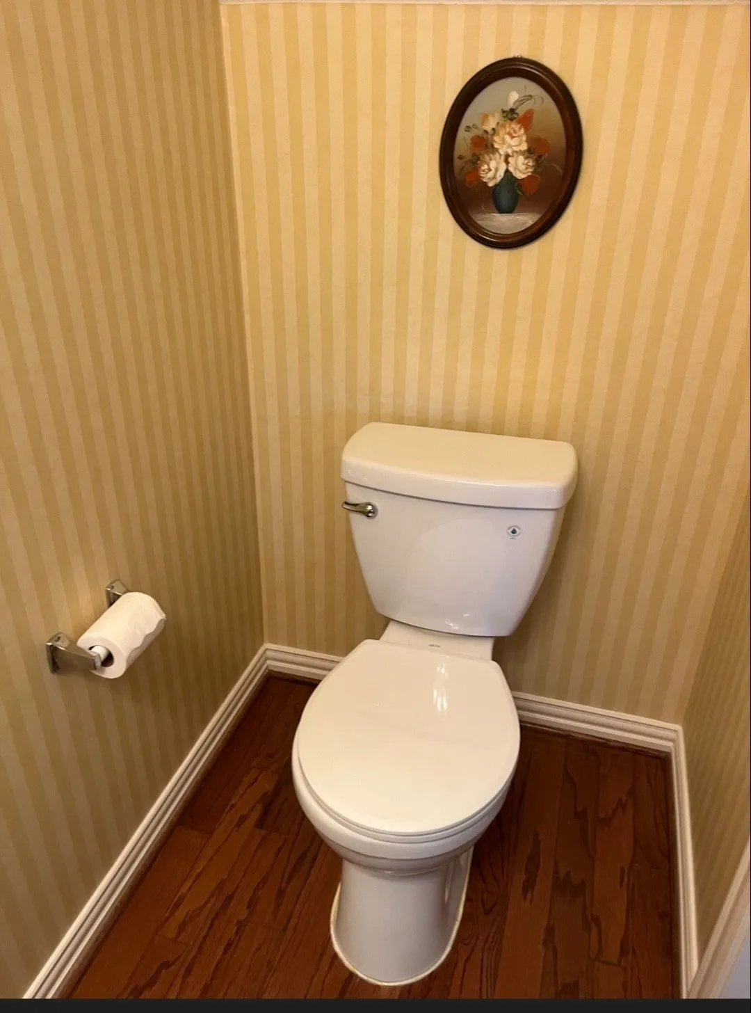 Interior space featuring wood-finish flooring, striped wallpaper, and white baseboards