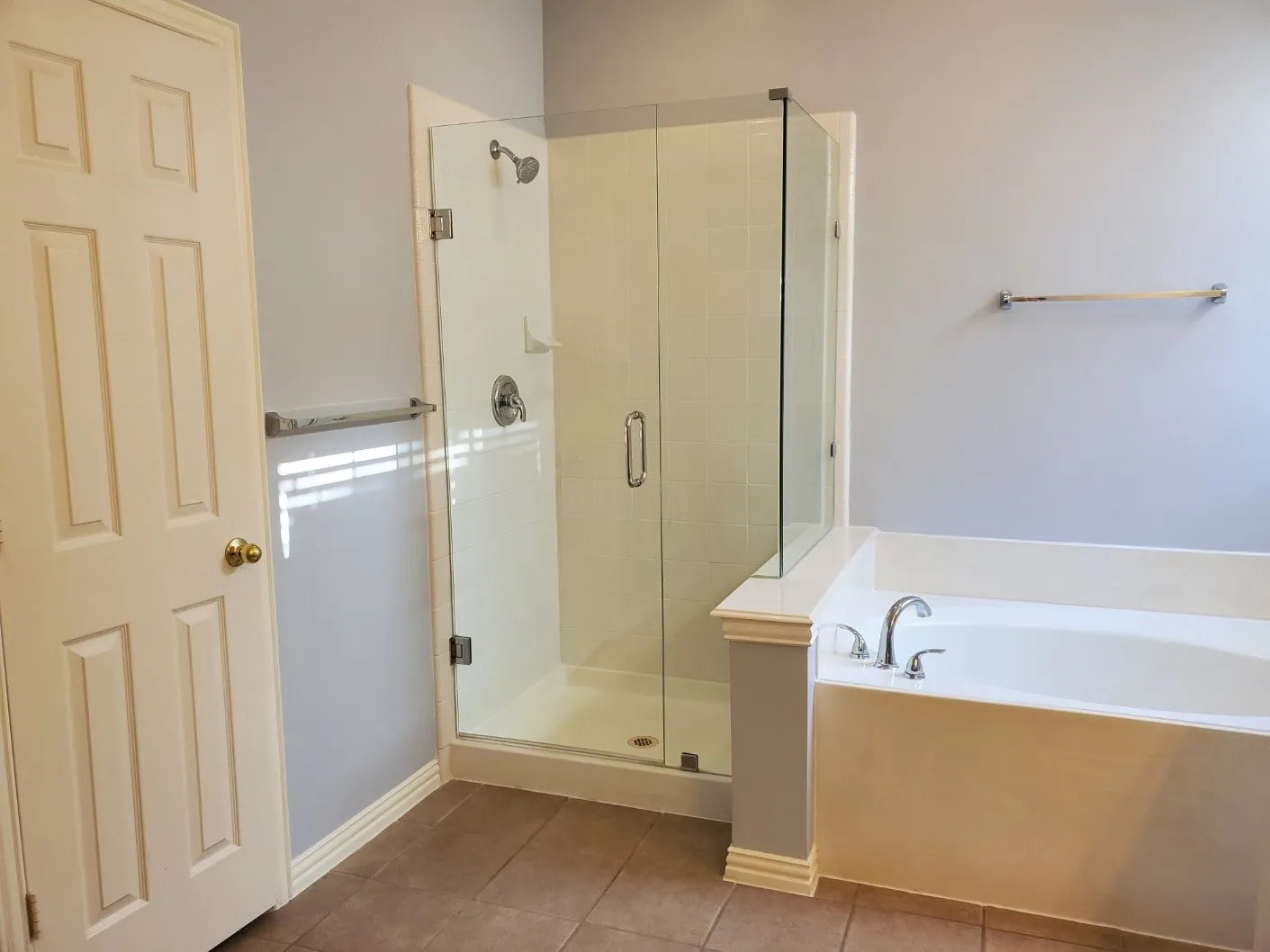 Bathroom featuring a glass-enclosed shower, built-in bathtub with deck-mounted faucet, and tile flooring