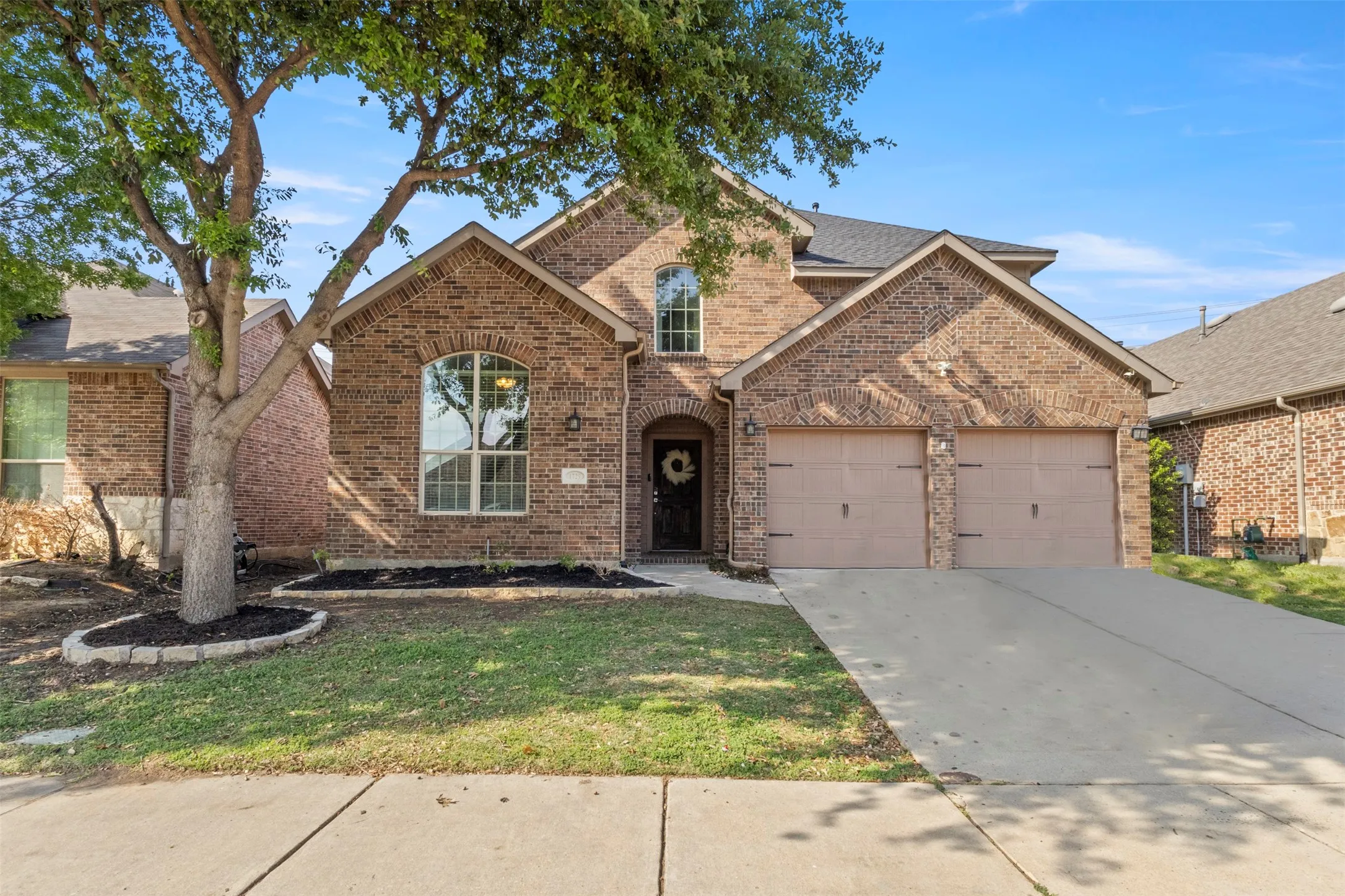 The property features a brick exterior, an attached two-car garage, and a concrete driveway