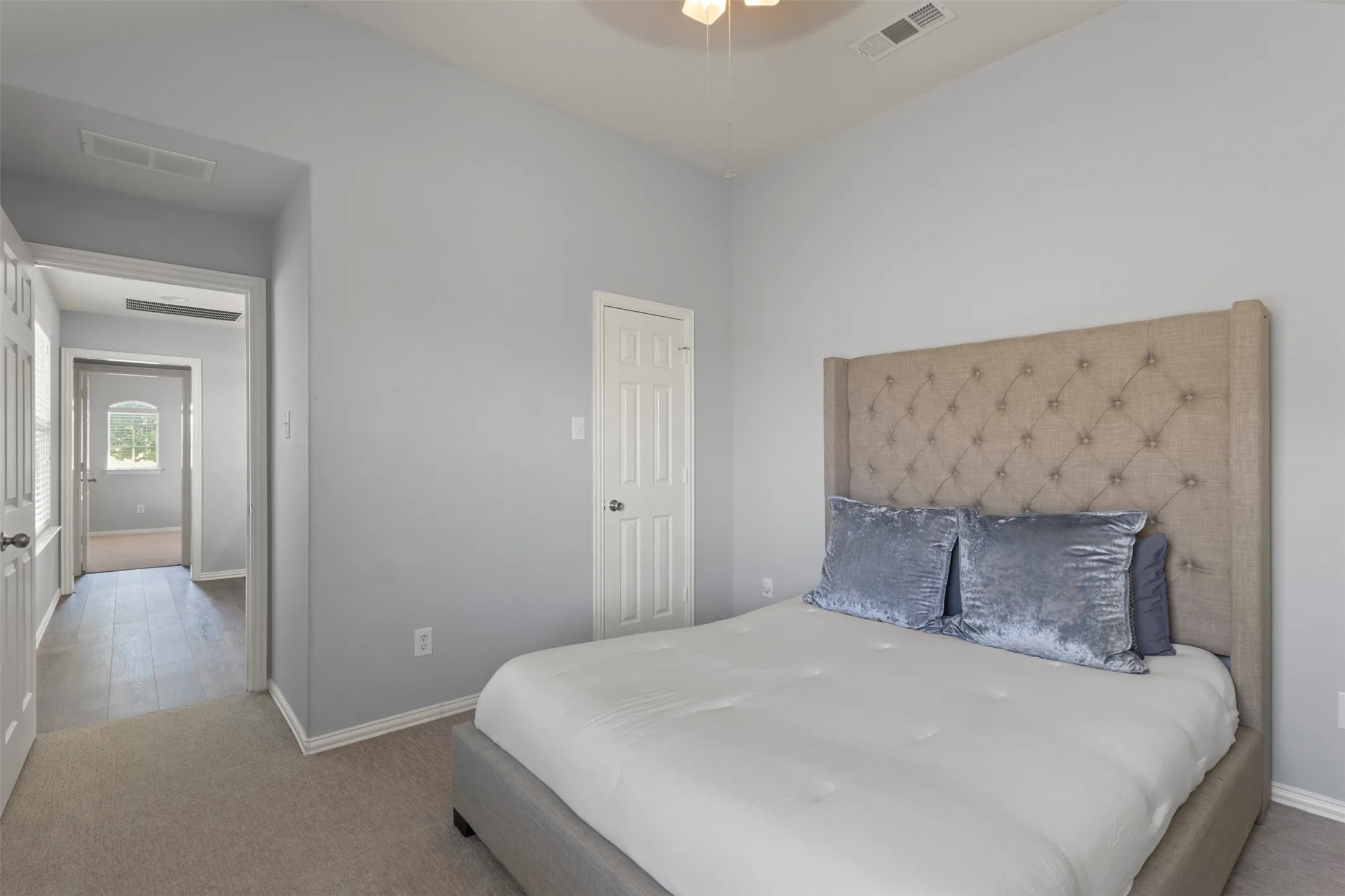 Bedroom featuring light grey walls, carpeted flooring, and a ceiling fan