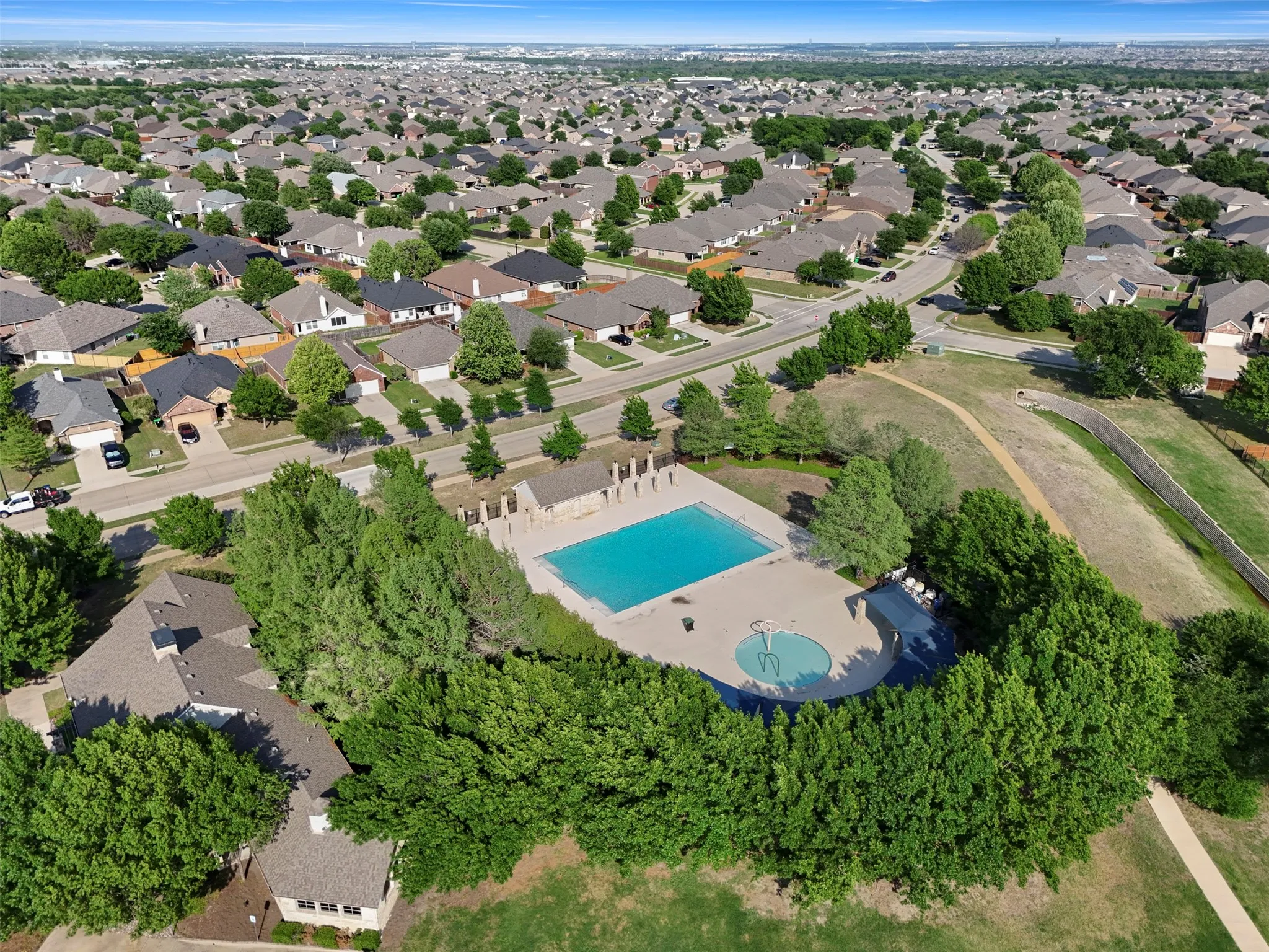 Aerial view of the community, showcasing residential properties with varying roof colors and surrounding green spaces