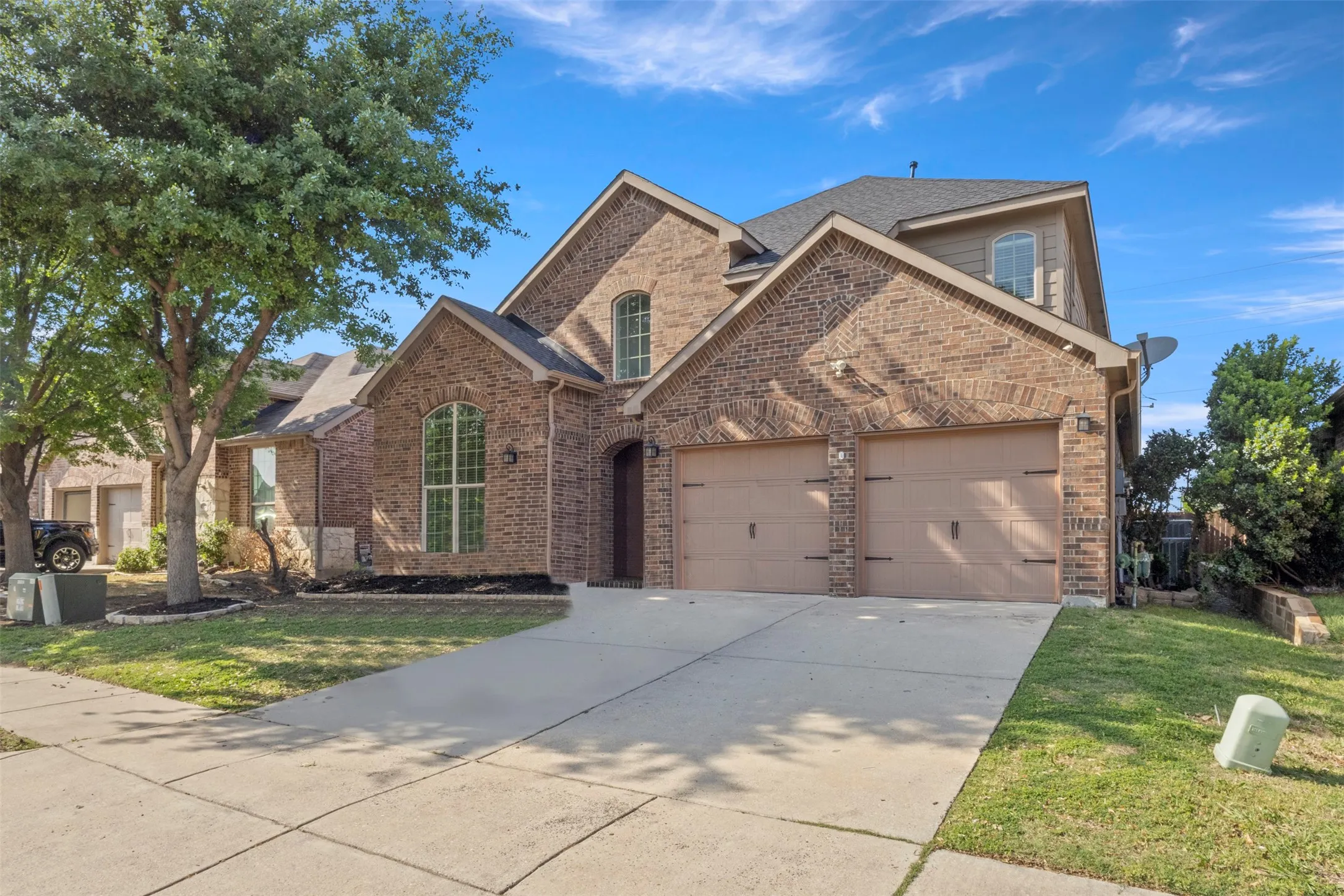 The property features a brick exterior with a multi-gabled roof and a two-car garage