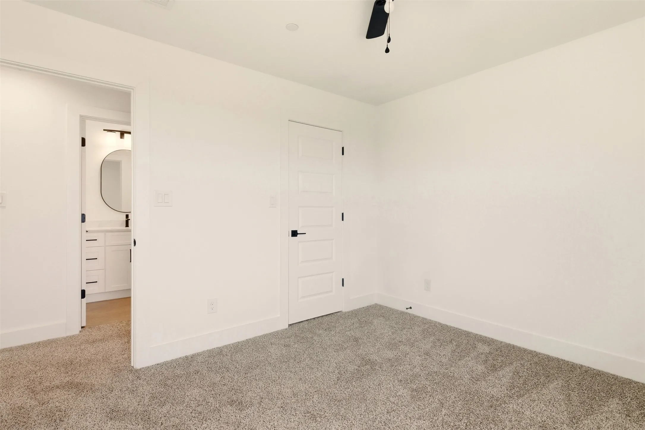 The room features light gray carpet flooring and white walls, with a white paneled door