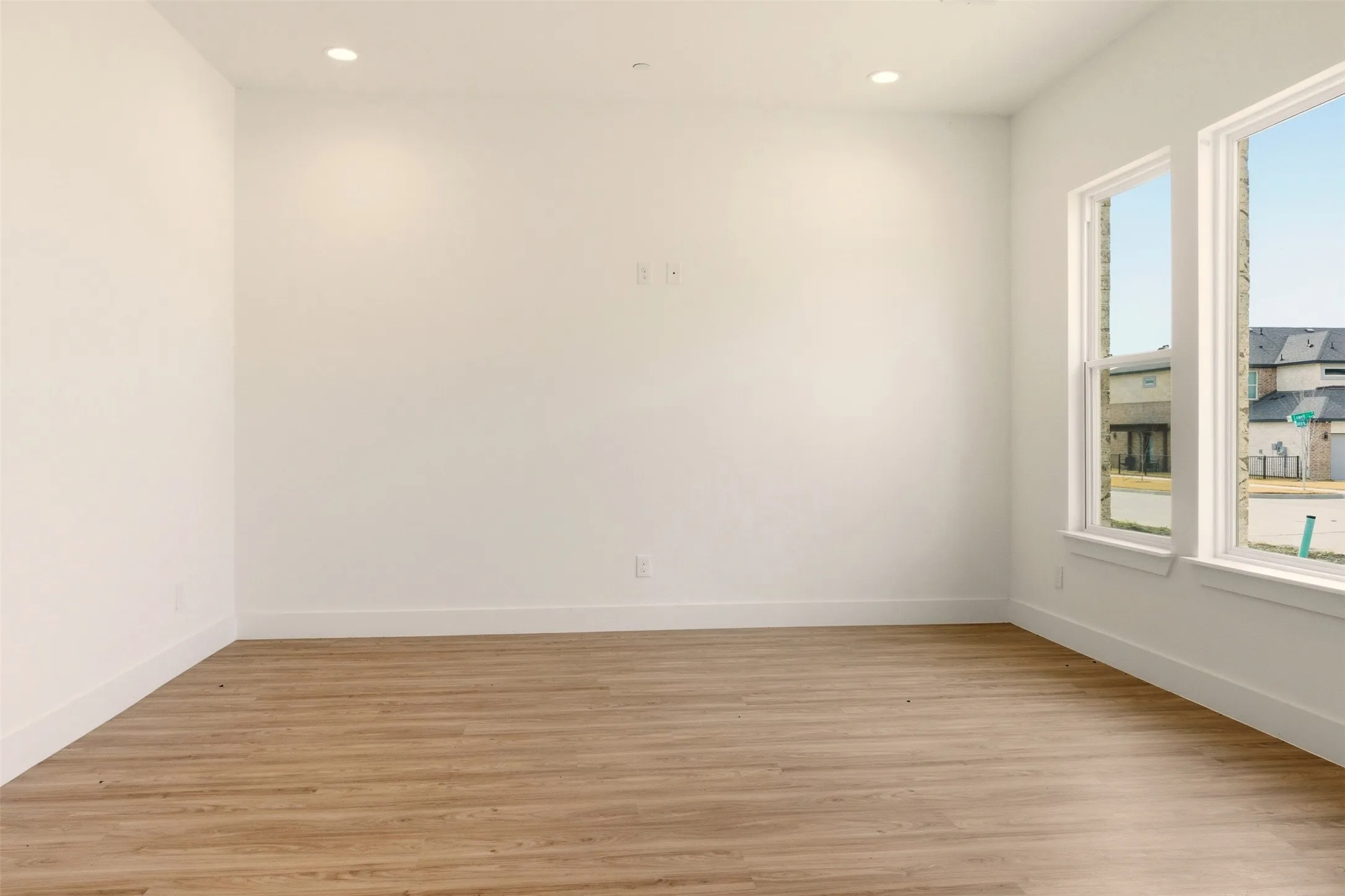 This interior space features light wood-look flooring, white walls, and recessed lighting