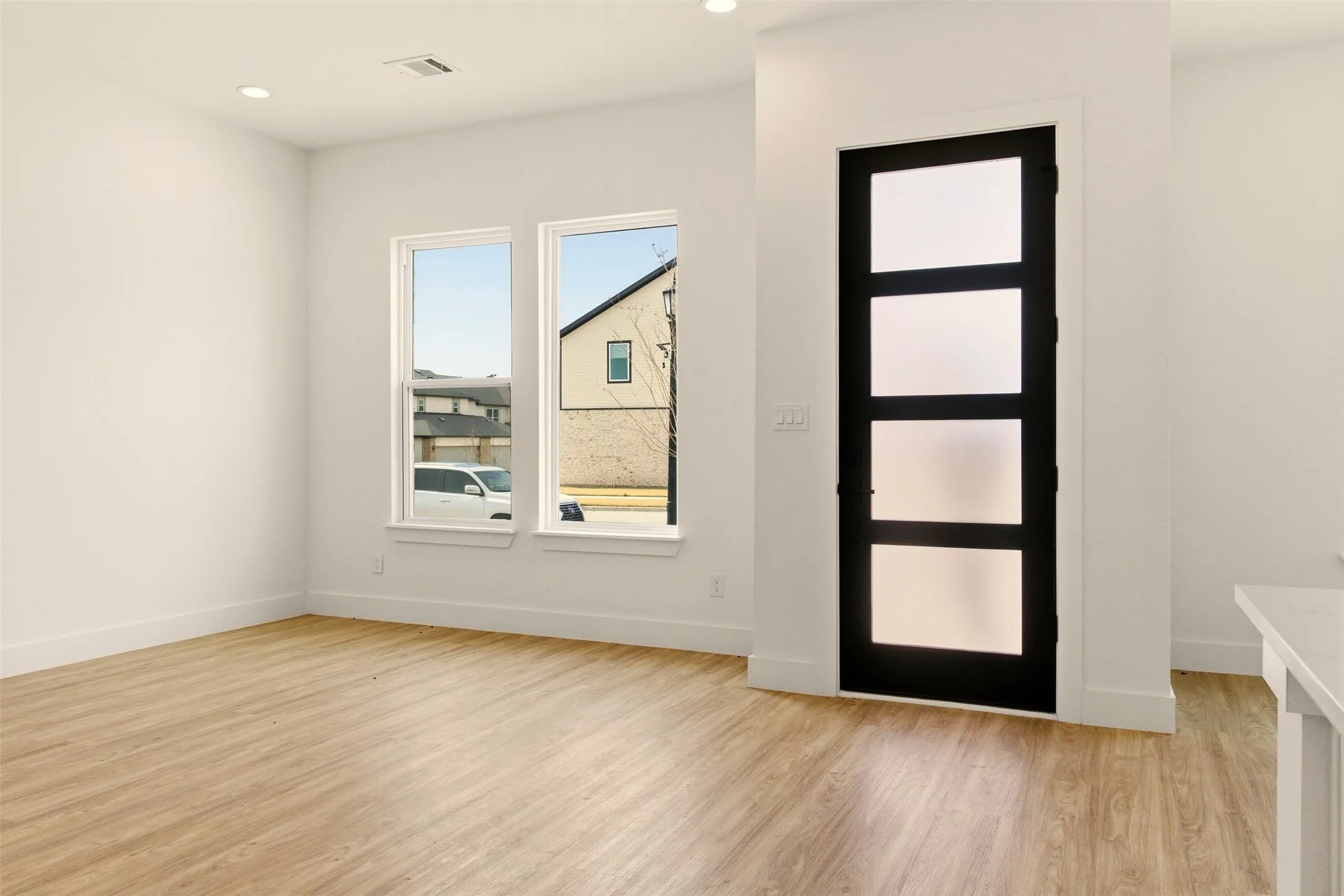 This room features light-colored flooring, white walls, and recessed lighting