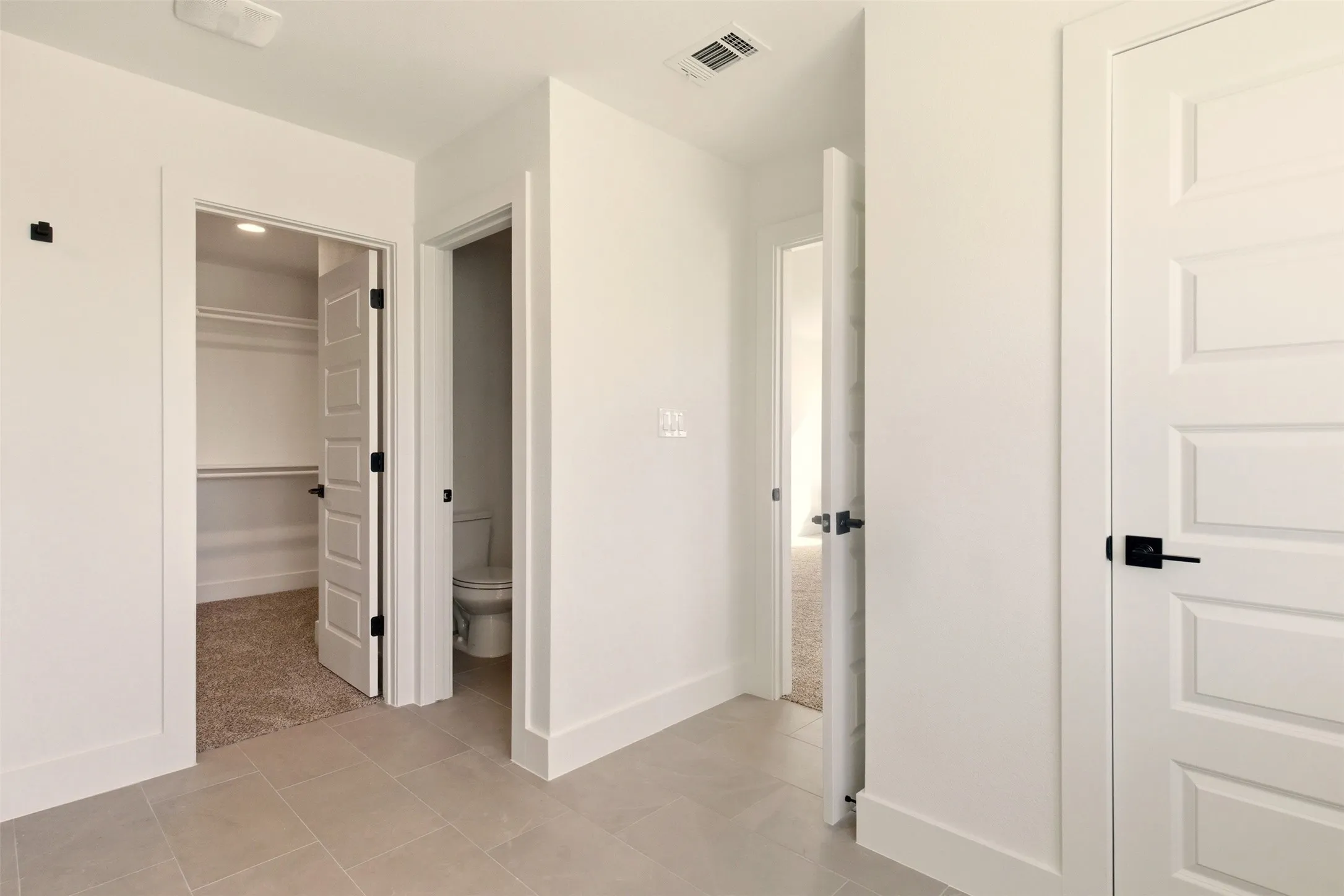 This area features light-colored tile flooring and white walls, with multiple white panel doors