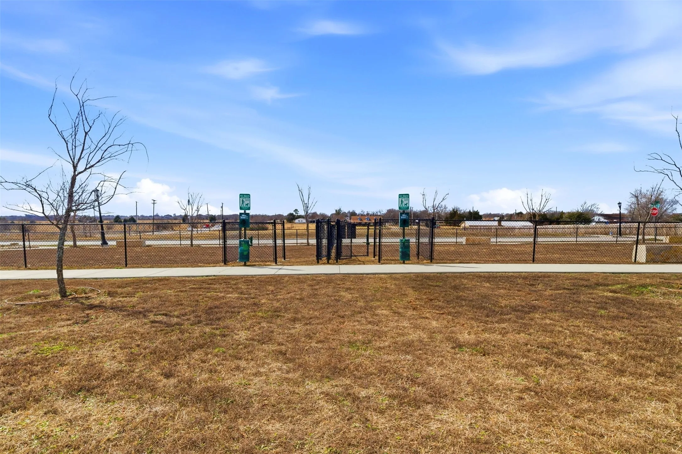 The property benefits from access to a fenced community area with a paved path and open grassy spaces