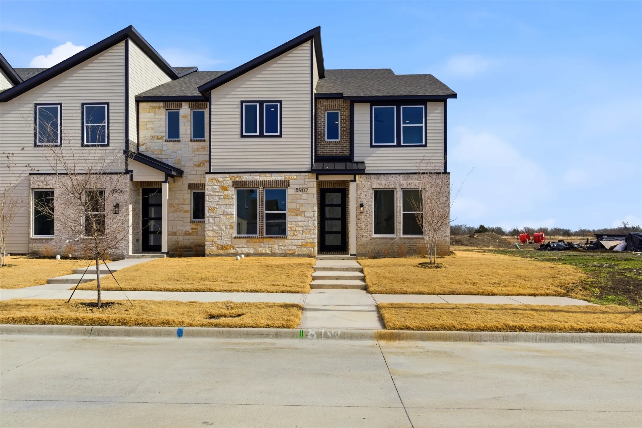 The property features a contemporary architectural style with a combination of light-colored siding and natural stone accents